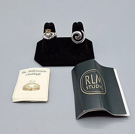2 Sterling Rings: Two size 7 Sterling Silver rings to include a Robert Lee Morris (RLM Studios) modern design ring and a sterling with gold overlay "Millenium claddagh" ring stamped JMH.If you have any doubt, please as