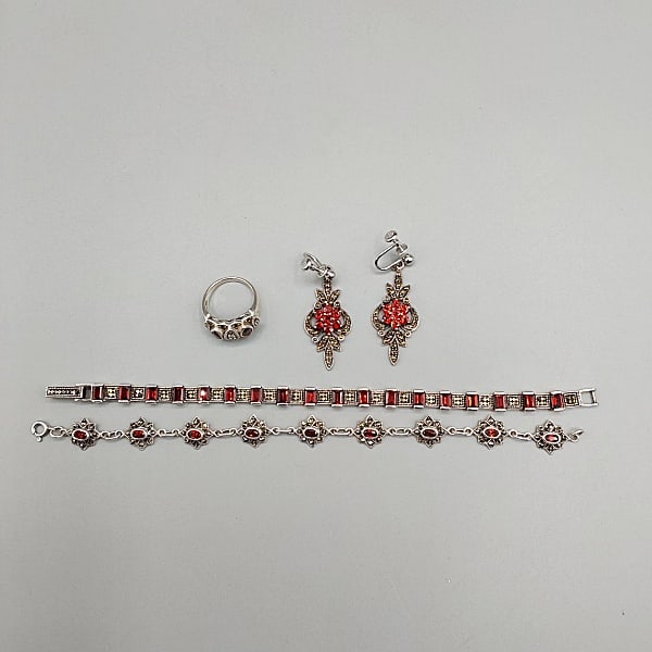 Sterling, Marcasite and Garnet: A grouping of sterling and garnet jewelry to include a 7 1/4" bracelet with marcasites, a 7 1/2" star design bracelet with marcasites, a ring (Size 7) with marcasites and a pair of earrings with vinta