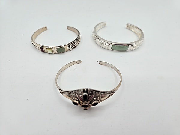 3 Sterling Cuff Bracelets: Three sterling silver cuff bracelets to include a Relios, INC Carolyn Pollack cuff bracelet with mother-of-pearl and other stones (2 1/4" across), a filigree and green stone cuff bracelet (2 1/4" acro