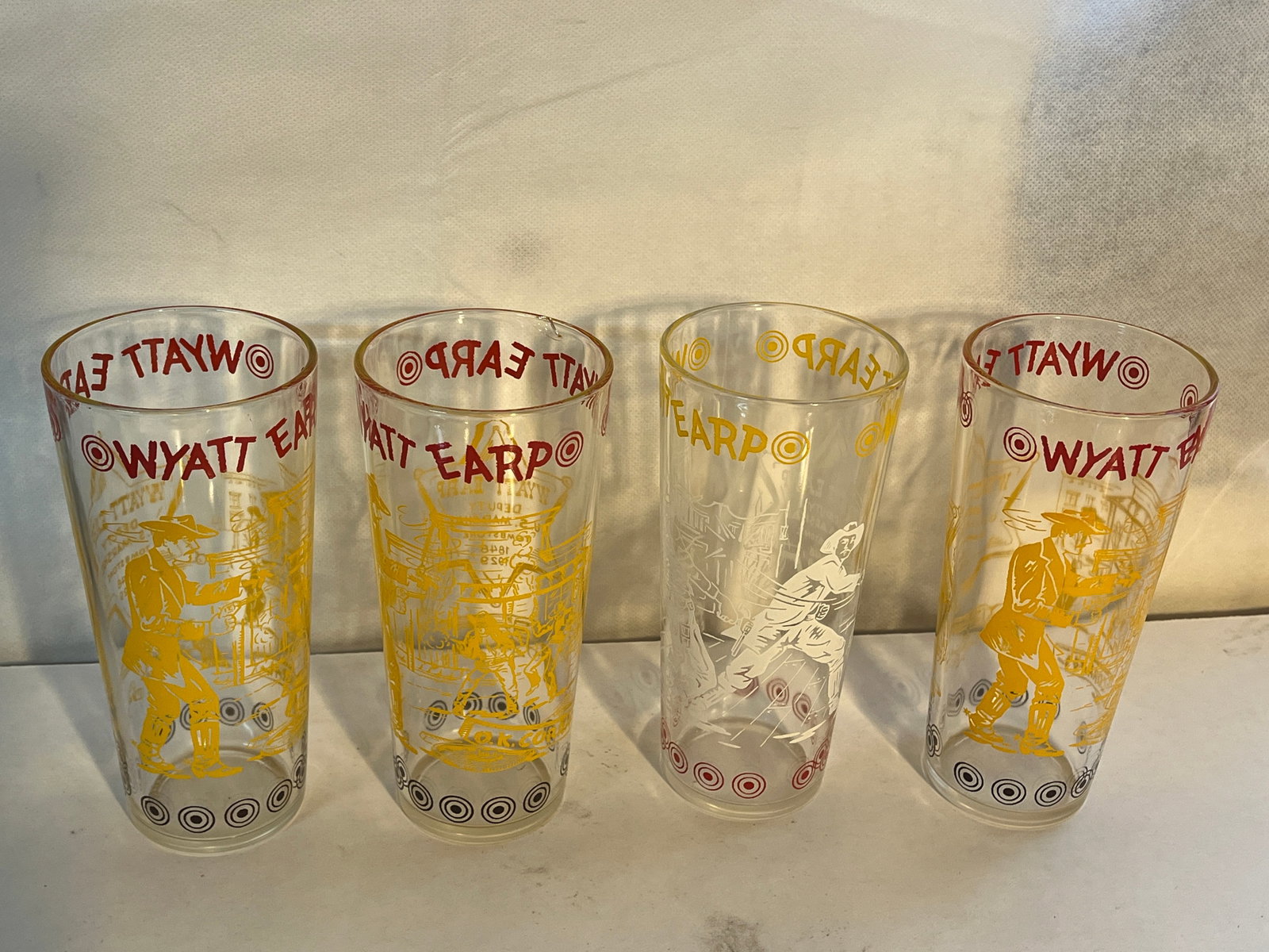 4 WYATT EARP DRINKING GLASSES: 1 HAS CHIP SEE PHOTOS