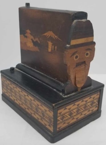 Mechanical Cigarette Dispenser: a very neat old item, inlaid design, open top to fill, press top button man's mouth opens and cigarette comes out, lower button opens drawer, very good condition, works great, about 4 1/2 inches tall