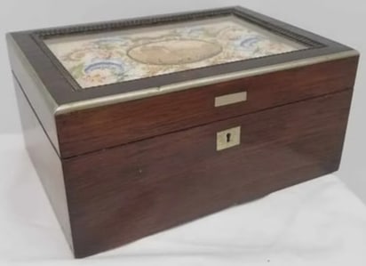 19th Century Box with Needlework Top Under Glass: A charming and elegant 19th-century decorative box, featuring a finely executed needlework panel set beneath glass. The top displays intricate hand-stitched detail, centered around a carved cork eleme