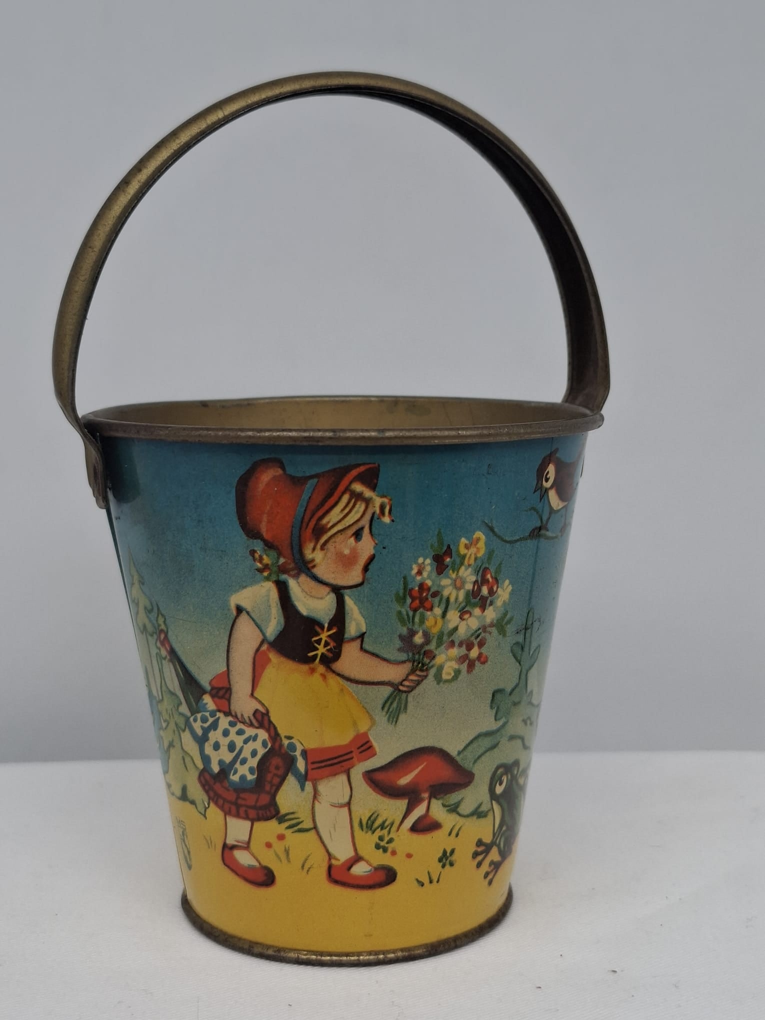 Early 20th Century Lithographed Tin Sand Pail – From Extensive European Collection: A charming and increasingly scarce early 20th century lithographed tin sand pail, exemplifying the colorful and imaginative design of classic seaside toys. This piece features vibrant period lithograp