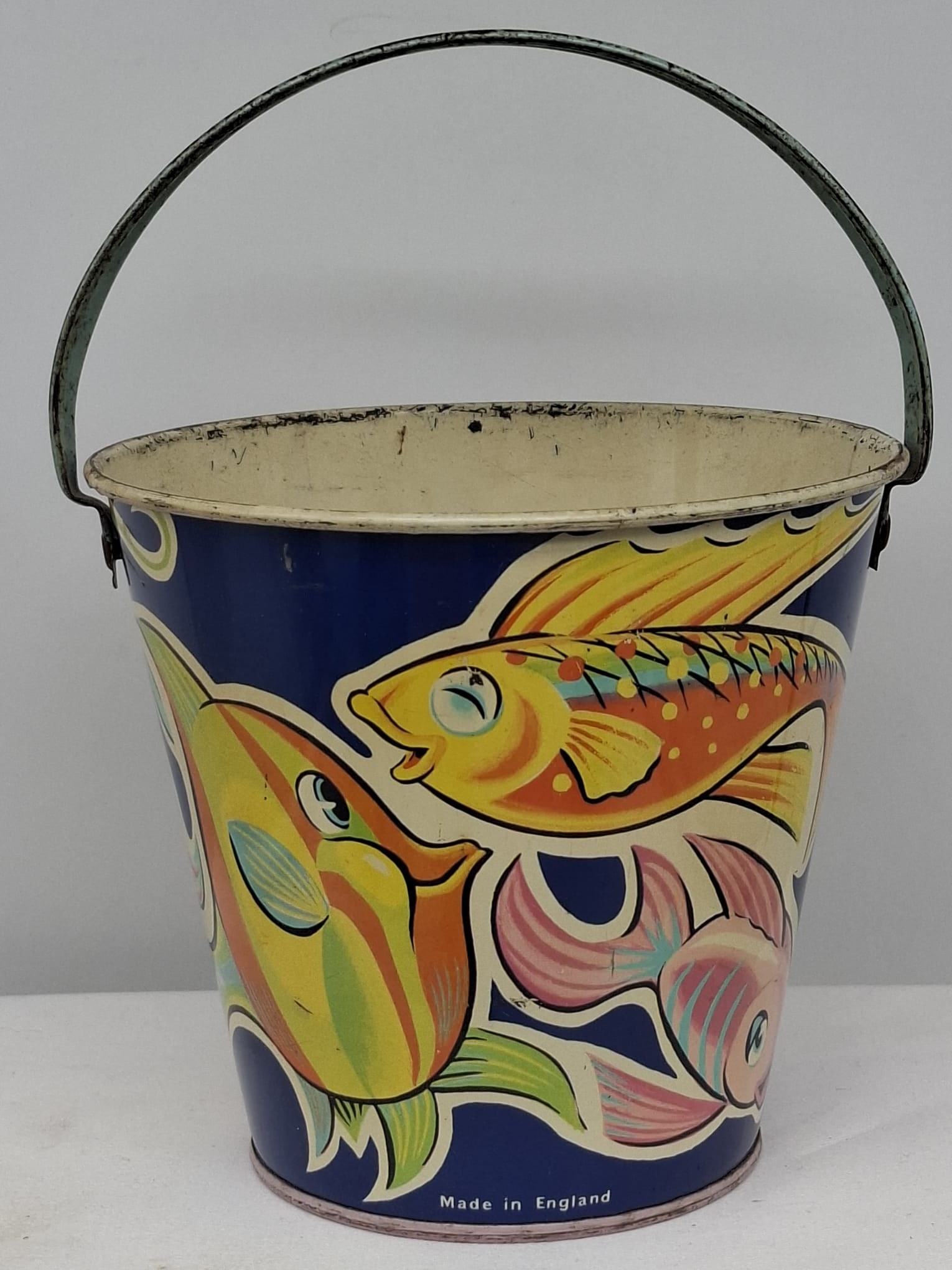 Early 20th Century Lithographed Tin Sand Pail – From Extensive European Collection: A charming and increasingly scarce early 20th century lithographed tin sand pail, exemplifying the colorful and imaginative design of classic seaside toys. This piece features vibrant period lithograp