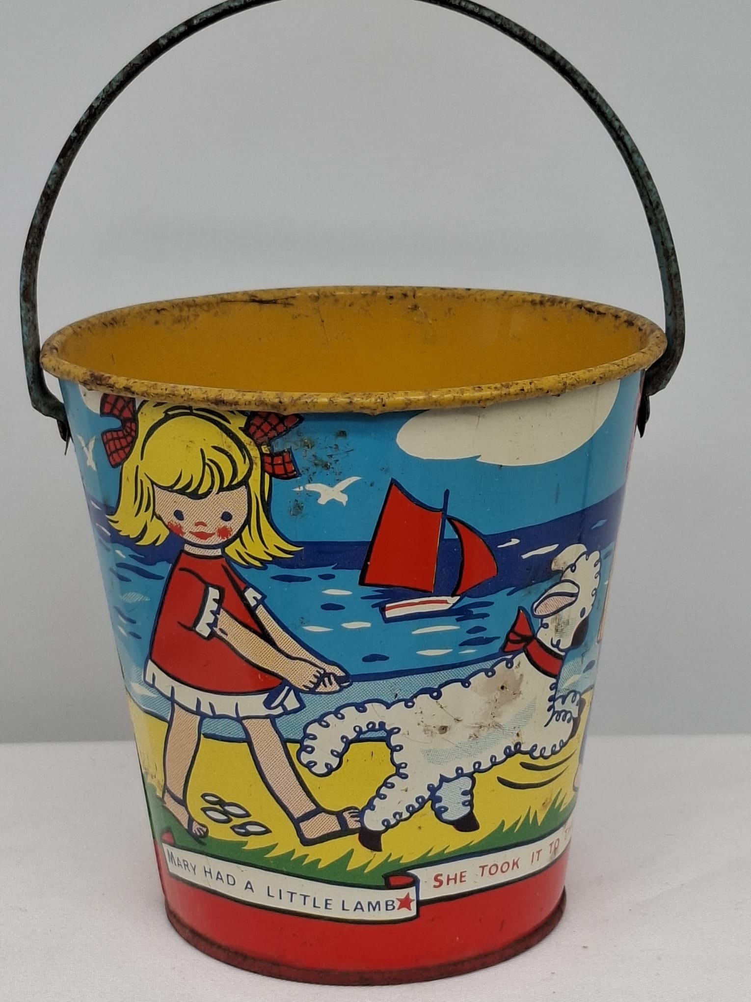 Early 20th Century Lithographed Tin Sand Pail – From Extensive European Collection: A charming and increasingly scarce early 20th century lithographed tin sand pail, exemplifying the colorful and imaginative design of classic seaside toys. This piece features vibrant period lithograp