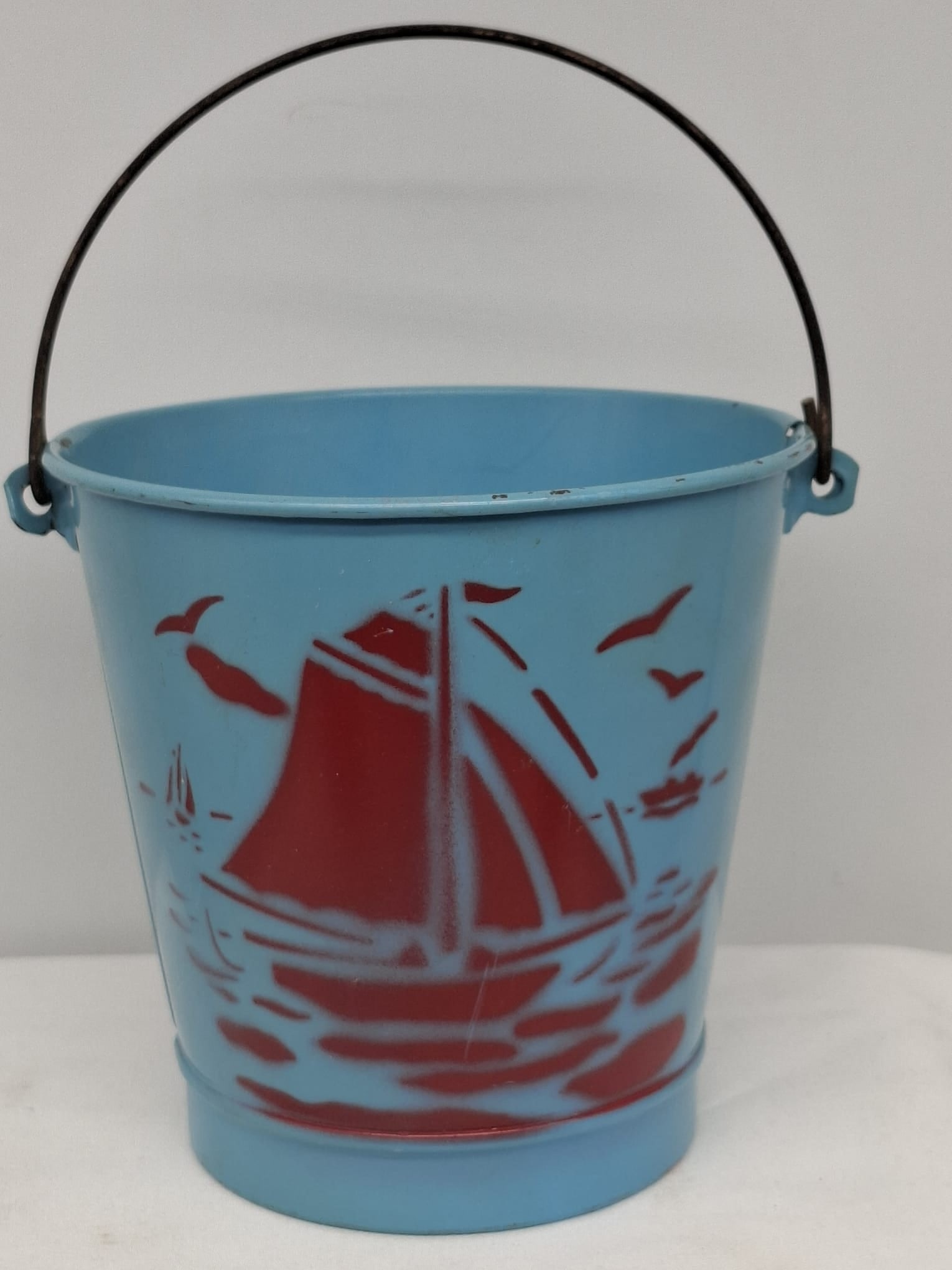 Early 20th Century Lithographed Tin Sand Pail – From Extensive European Collection: A charming and increasingly scarce early 20th century lithographed tin sand pail, exemplifying the colorful and imaginative design of classic seaside toys. This piece features vibrant period lithograp