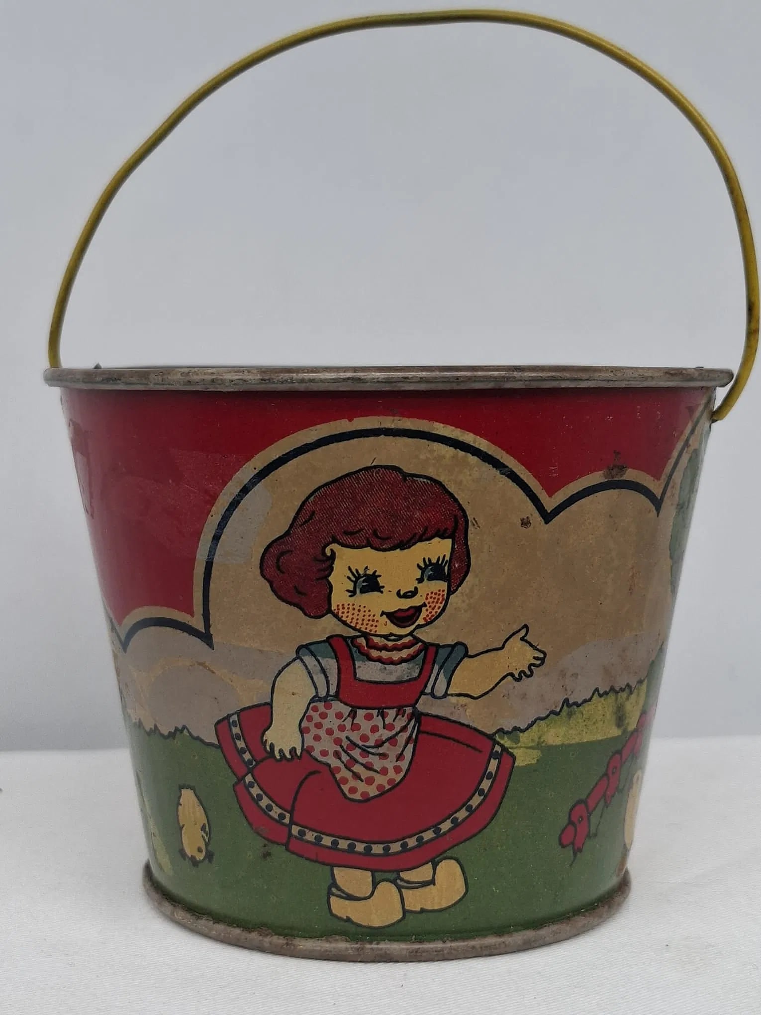 Early 20th Century Lithographed Tin Sand Pail – From Extensive European Collection: A charming and increasingly scarce early 20th century lithographed tin sand pail, exemplifying the colorful and imaginative design of classic seaside toys. This piece features vibrant period lithograp