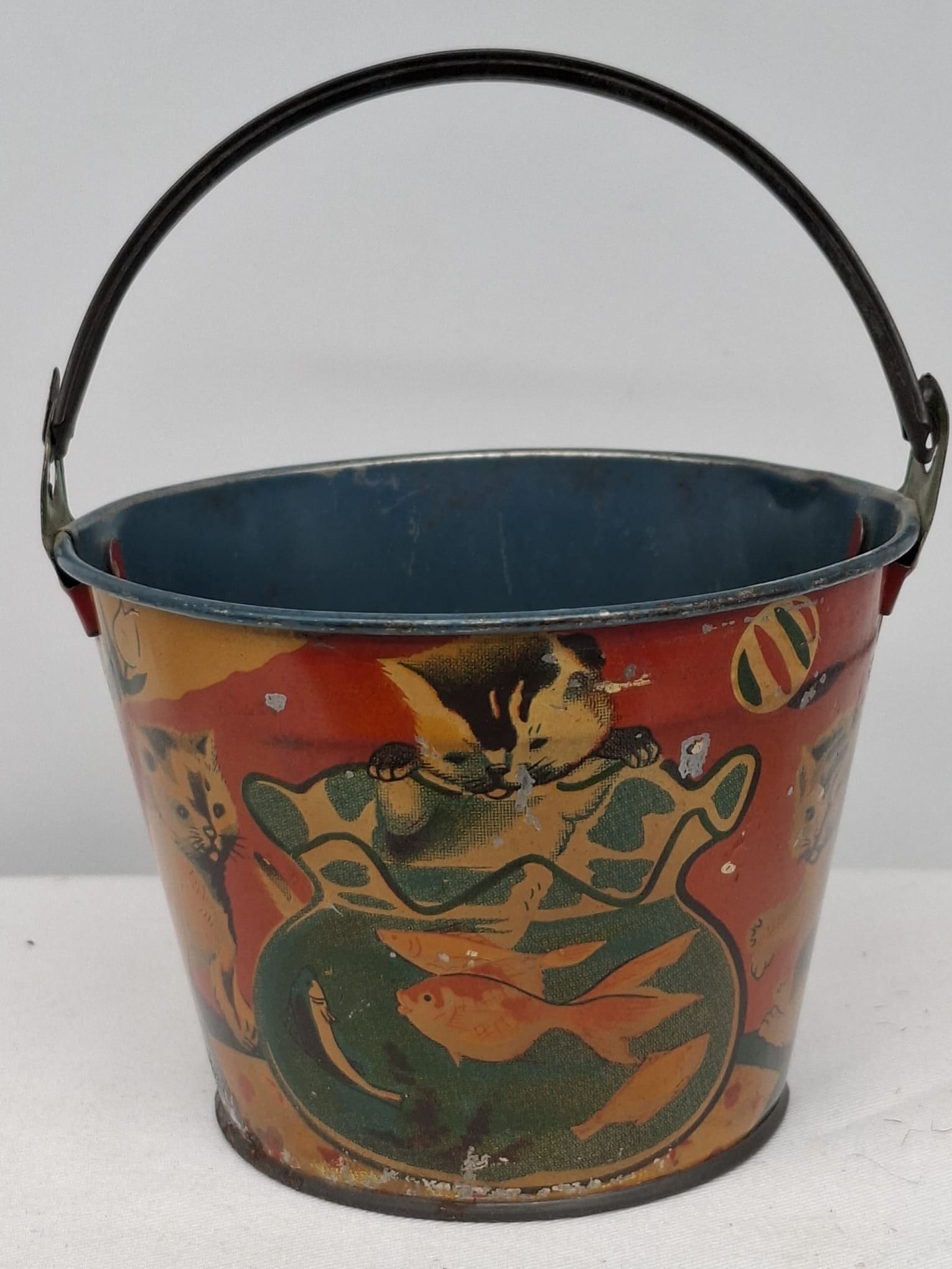 Early 20th Century Lithographed Tin Sand Pail – From Extensive European Collection: A charming and increasingly scarce early 20th century lithographed tin sand pail, exemplifying the colorful and imaginative design of classic seaside toys. This piece features vibrant period lithograp