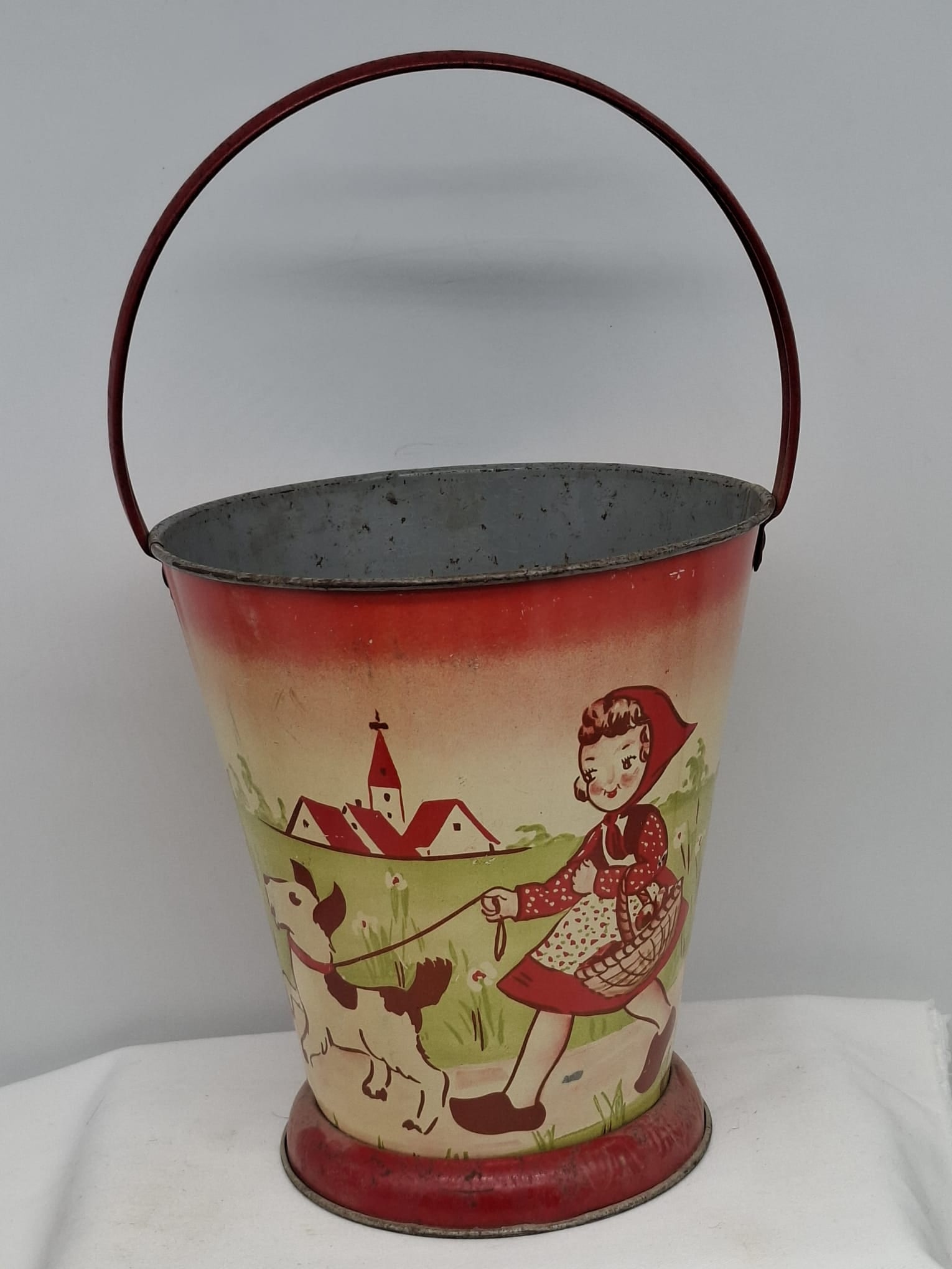 Early 20th Century Lithographed Tin Sand Pail – From Extensive European Collection: A charming and increasingly scarce early 20th century lithographed tin sand pail, exemplifying the colorful and imaginative design of classic seaside toys. This piece features vibrant period lithograp
