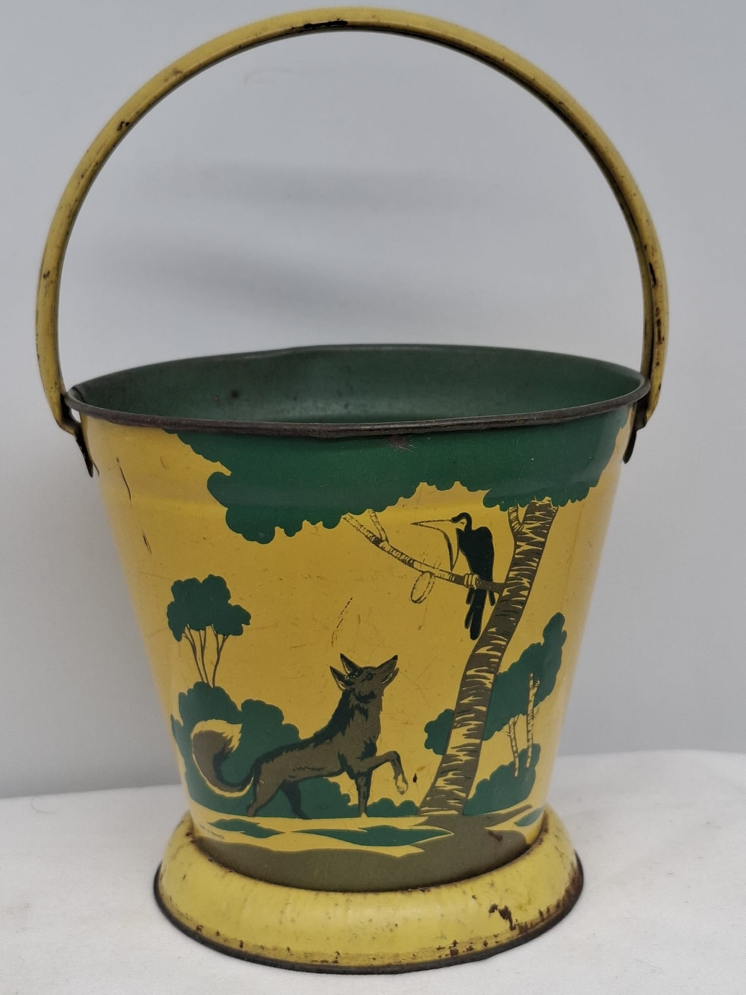 Early 20th Century Lithographed Tin Sand Pail – From Extensive European Collection: A charming and increasingly scarce early 20th century lithographed tin sand pail, exemplifying the colorful and imaginative design of classic seaside toys. This piece features vibrant period lithograp