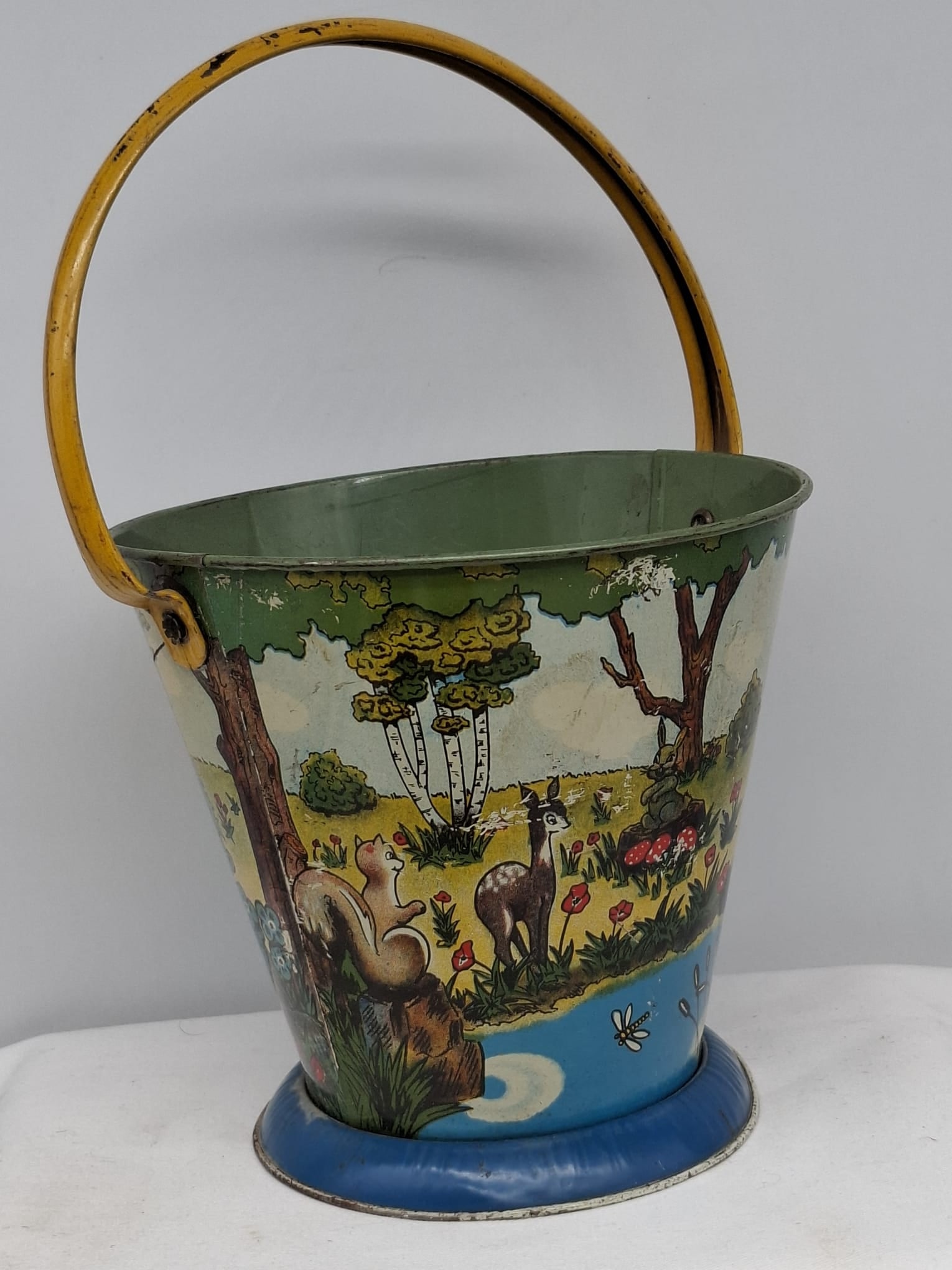 Early 20th Century Lithographed Tin Sand Pail – From Extensive European Collection: A charming and increasingly scarce early 20th century lithographed tin sand pail, exemplifying the colorful and imaginative design of classic seaside toys. This piece features vibrant period lithograp
