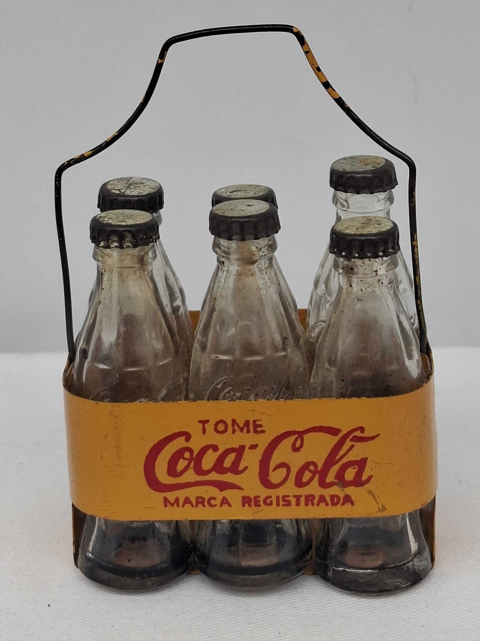 Rare Miniature Coca-Cola Bottle Carrier with Glass Bottles: An exceptionally rare and highly desirable miniature Coca-Cola bottle carrier set, seldom encountered in today’s market. This charming and scarce example includes its original tin carrier along with