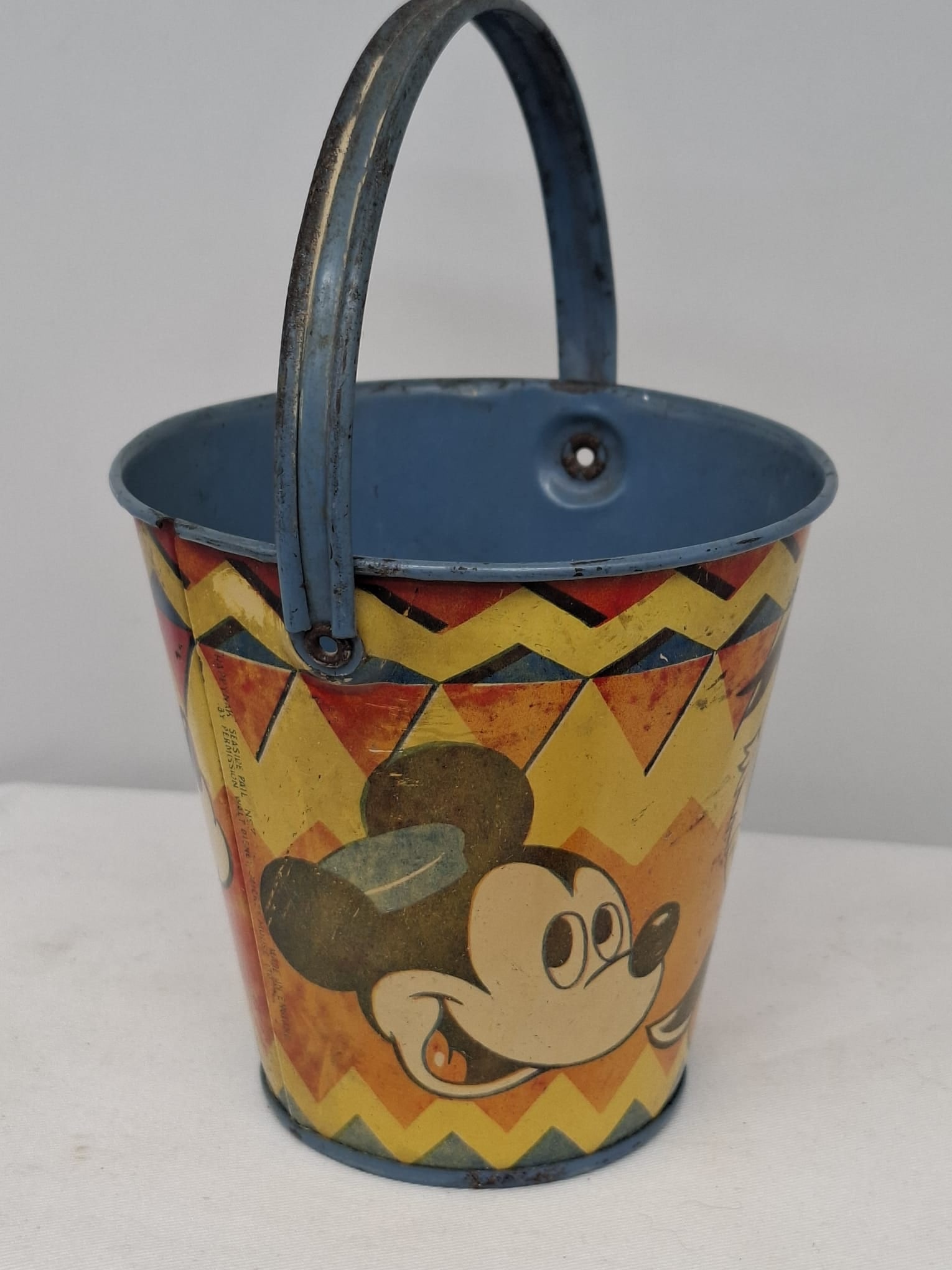 Early 20th Century Walt Disney Tin Sand Pail – From Extensive European Collection: A charming and increasingly scarce early 20th century Walt Disney tin sand pail, exemplifying the colorful and imaginative design of classic seaside toys. This piece features vibrant period lithograph