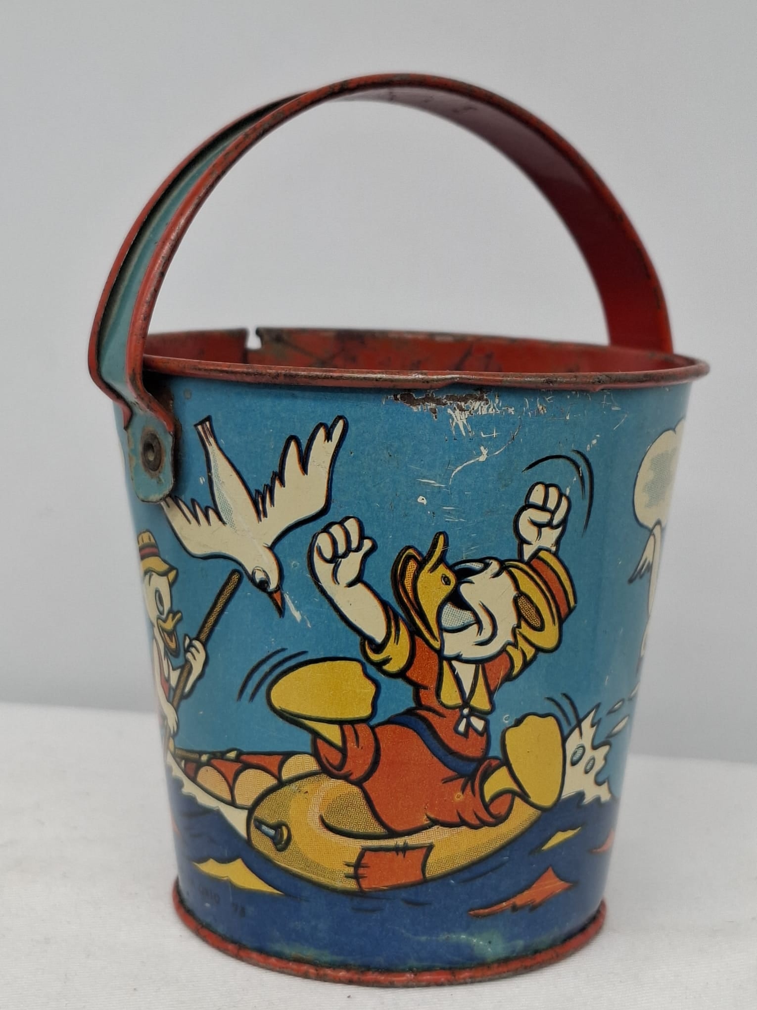 Early 20th Century Walt Disney Tin Sand Pail – From Extensive European Collection: A charming and increasingly scarce early 20th century Walt Disney tin sand pail, exemplifying the colorful and imaginative design of classic seaside toys. This piece features vibrant period lithograph