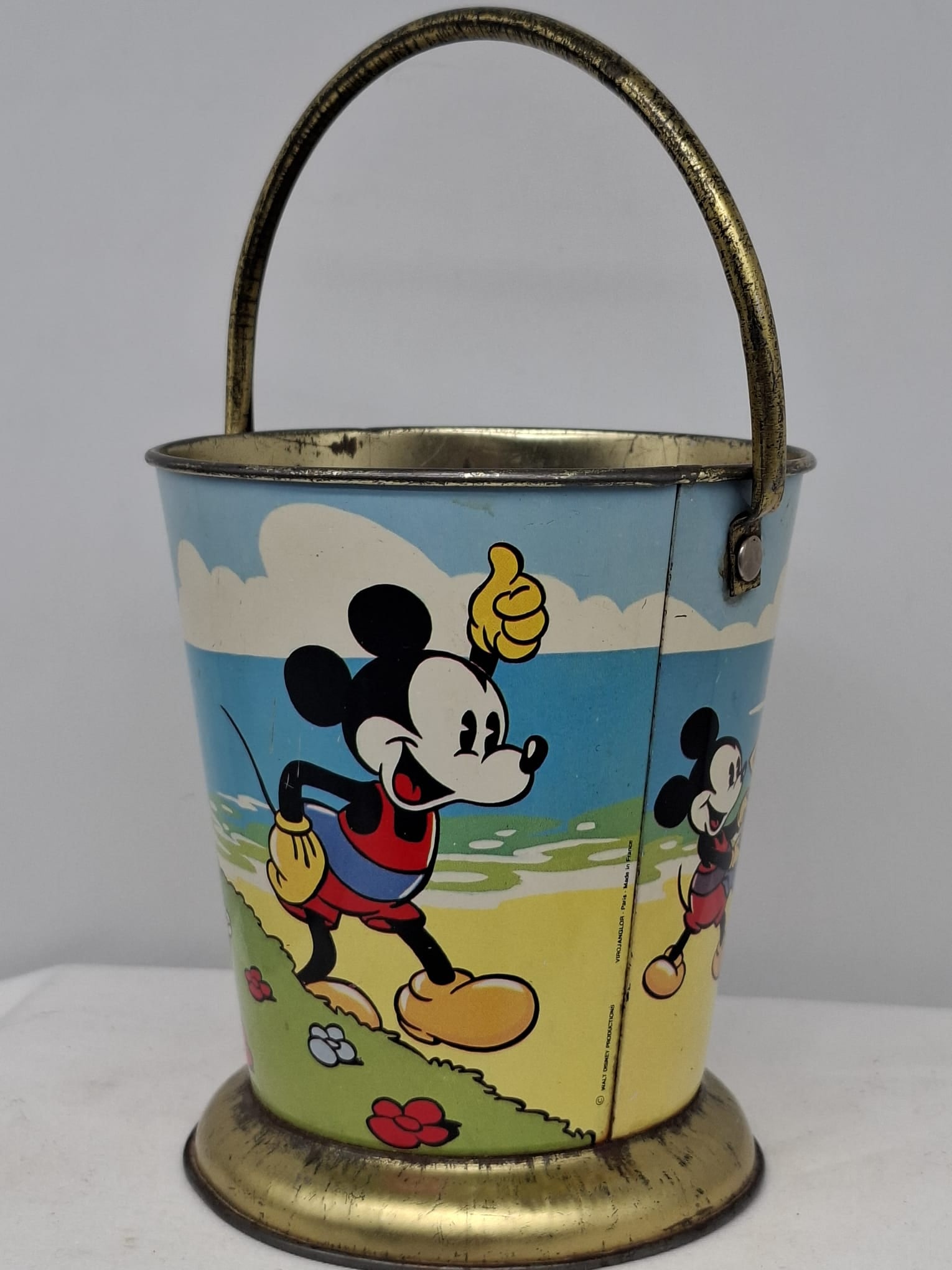 Early 20th Century Walt Disney Tin Sand Pail – From Extensive European Collection: A charming and increasingly scarce early 20th century Walt Disney tin sand pail, exemplifying the colorful and imaginative design of classic seaside toys. This piece features vibrant period lithograph