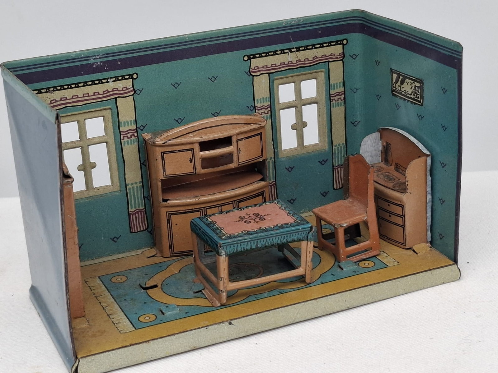 Orobr Miniature Tin Toy Room – Furnished Interior Scene – Mid 20th Century: A charming Orobr miniature toy room, crafted in tin and featuring a delightful furnished interior scene in miniature form. Measuring approximately 5 inches wide, this petite piece showcases the ingenu