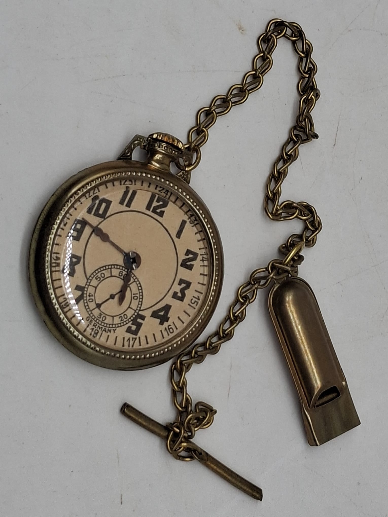 Antique Tin Penny Toy Pocket Watch with Chain and Fob, Circa 1910: Charming early 20th-century tin penny toy in the form of a miniature pocket watch, complete with attached chain and fob, dating to circa 1910. This whimsical novelty piece reflects the fascination wit