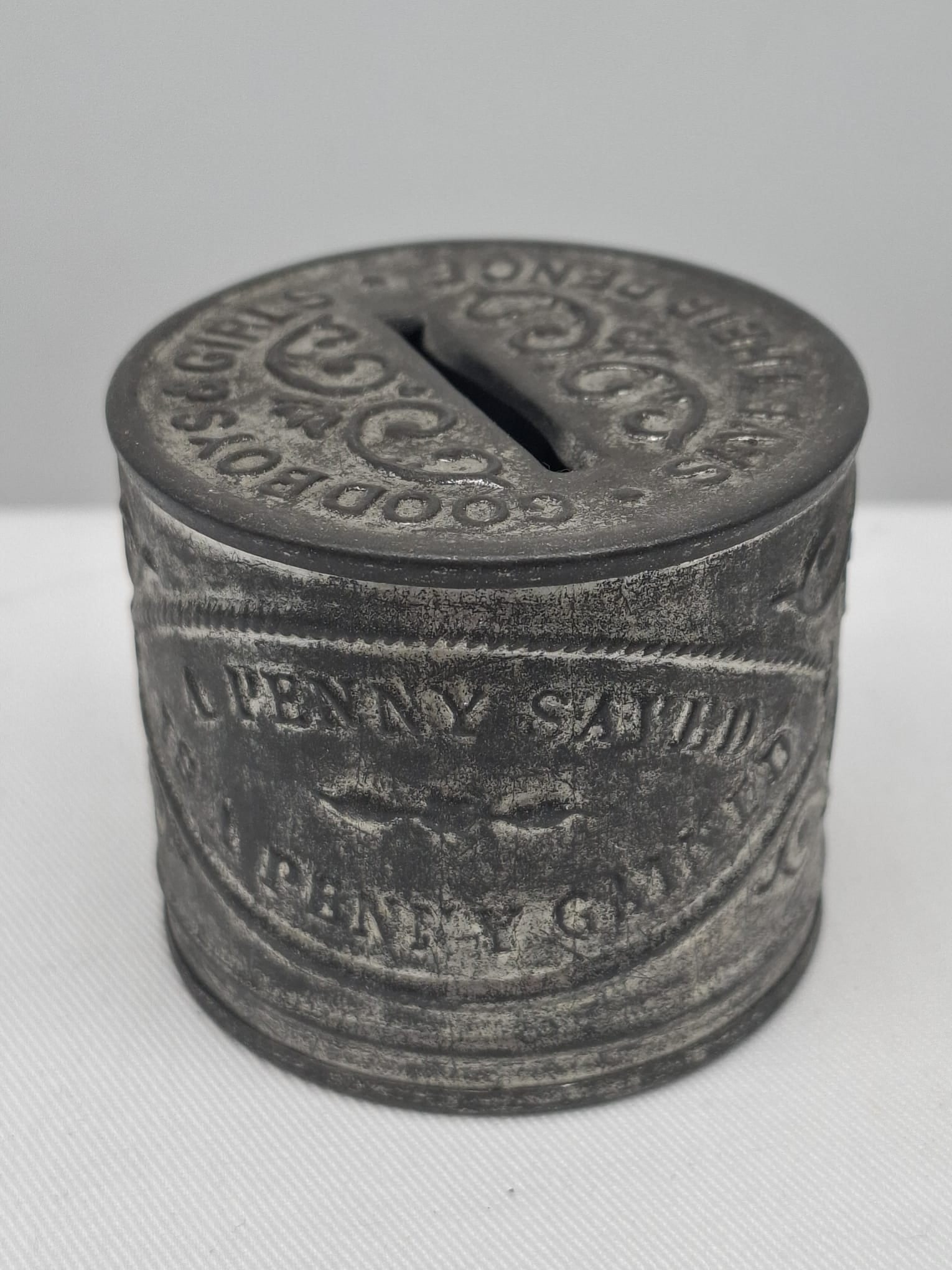 Late 19th Century Embossed Tin “Franklin’s Maxims” Penny Bank: An unusual and charming late 19th-century embossed tin penny bank featuring sayings inspired by Benjamin Franklin’s famous “Maxims,” the widely circulated proverbs promoting thrift, industry