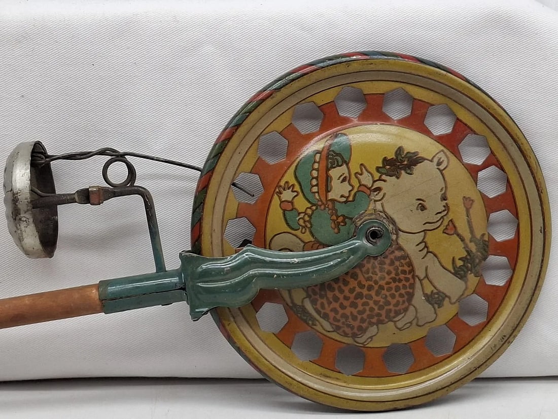 Vintage Push-Along Bell Toy – “Mary Had a Little Lamb” – Lithographed Tin with Wooden: A charming early 20th-century push-along bell toy, circa 1920, featuring colorful lithographed tin decoration and a sturdy wooden handle. The playful “Mary Had a Little Lamb” motif adds