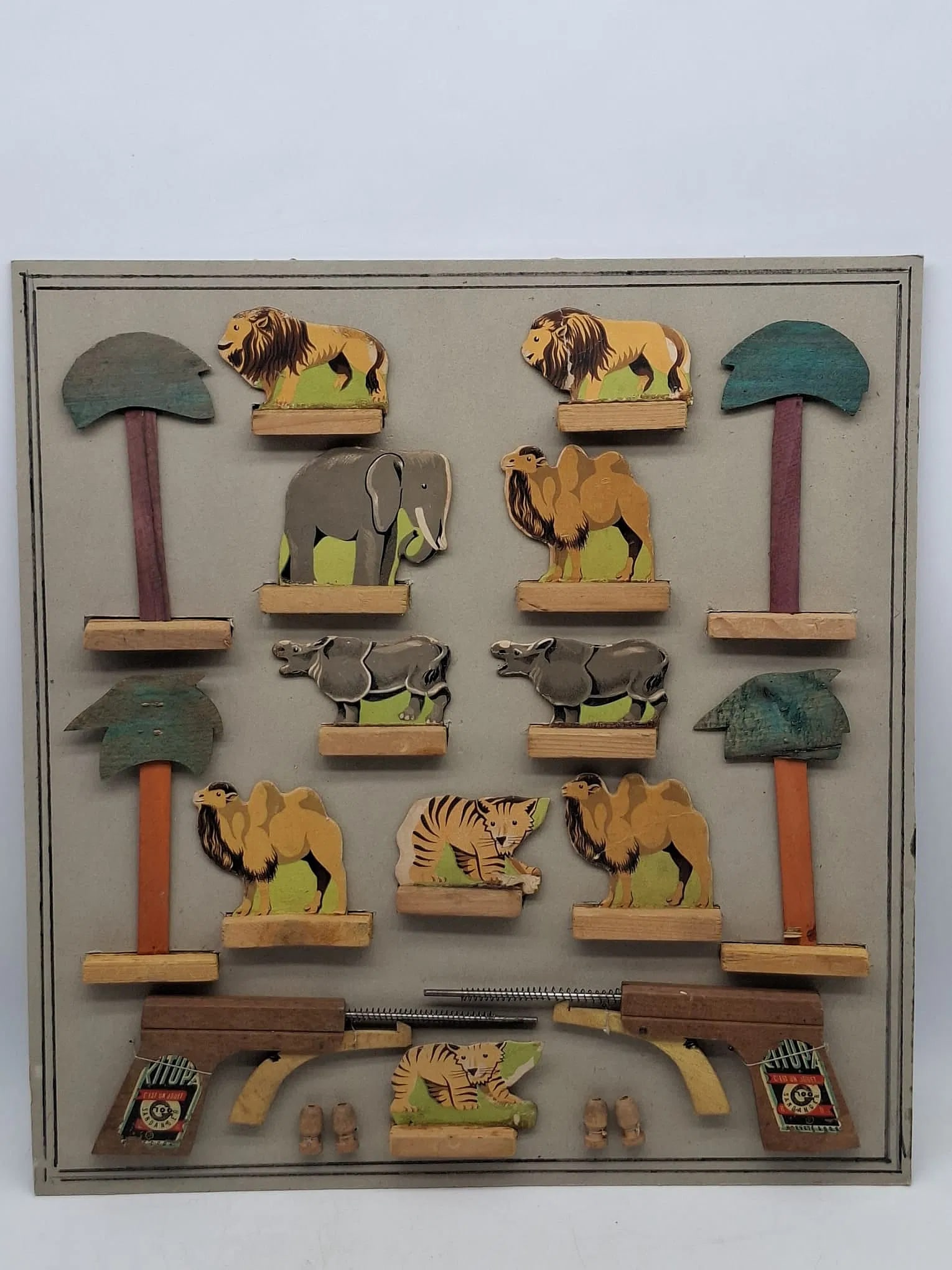 French Safari Die-Cut Cardboard Toy Set on Original Card, Interwar Period: Charming French safari toy set featuring die-cut cardboard figures mounted on wooden bases and presented on the original printed display card. Produced in Paris during the interwar period, likely