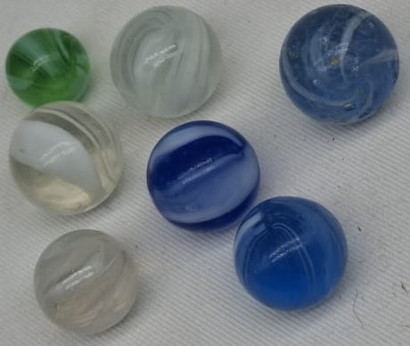 Grouping of Handmade German Glass Marbles, Early 20th Century: A charming grouping of handmade German glass marbles dating to the early 1900s. These attractive marbles measure approximately 1.5 cm (0.6 inches) in diameter and showcase the craftsmanship for which 