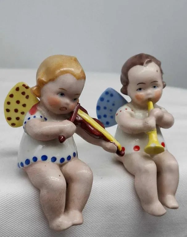 Porcelain Angel Shelf Sitters: Two very cute little porcelain angels, they are designed to sit on the edge of a shelf, they are about 3 1/2 inches tall, the tip of the horn has been broken off and glued.