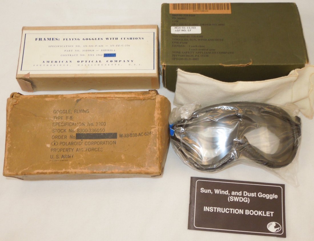 Lot of WWII - Modern US Flying Goggles Boxes: Lot of three goggles boxes. One is a 2000s dated Army Sun Wind Dust Goggles in box with extra lens and manual, an empty Navy goggles box, and an empty Army Air Force B-8 Goggles box.