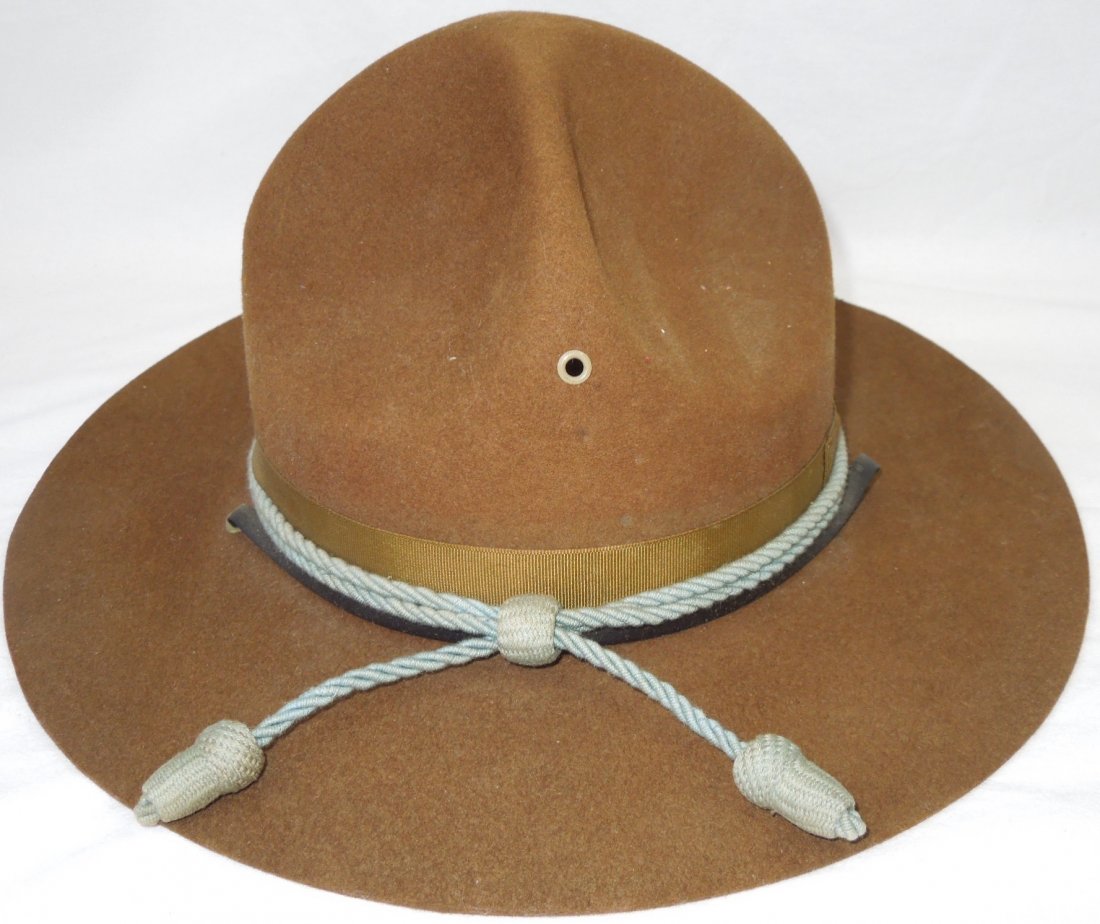 WWII - 50s US Army Infantry Stetson Campaign Hat: Campaign Hat with blue acorn infantry cap cord. Brown OD wool. Black plastic strap. No size present. In very good condition. (II D 602)