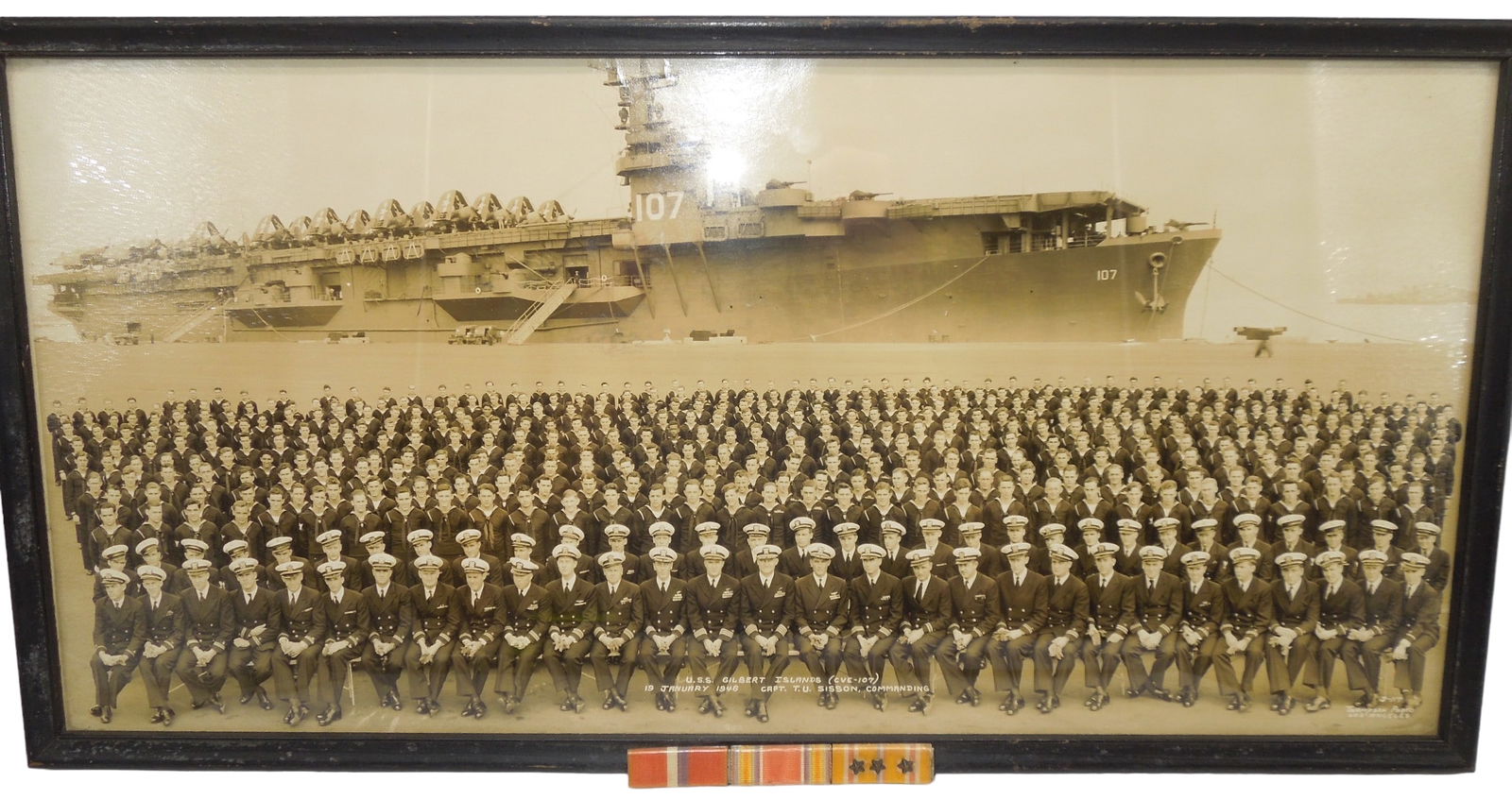 Post WWII 1946 USN Navy USS Gilbert Islands Ship Unit Photo & Ribbon Bar: Post WWII 1946 USN Navy USS Gilbert Islands (CVE-107) Ship Unit Photo. Dated 19 January 1946. Captain T.U. Sisson, Commanding. Attached to the frame is a ribbon bar that includes Philippine Liberation