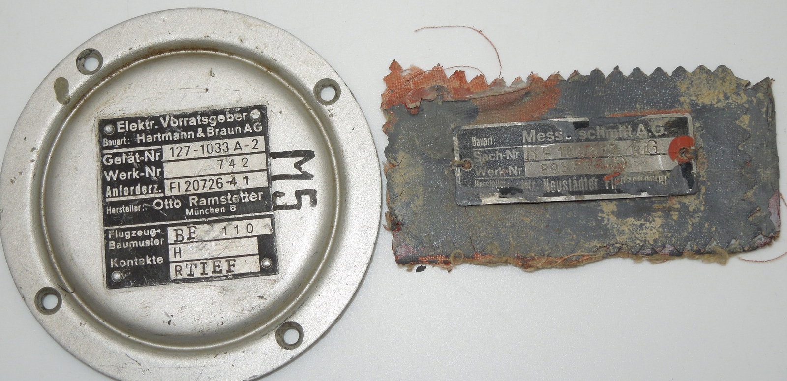 WWII Era German Messerschmitt BF 109, Hartmann & Braun Instrument Panel Data Plates: WWII Era German Luftwaffe Messerschmitt BF 109 Fighter Aircraft & Hartmann & Braun Instrument Panel Plates. The Messerschmitt BF 109 is attached to a piece of Aircraft fabric. Unfortunately, we are un