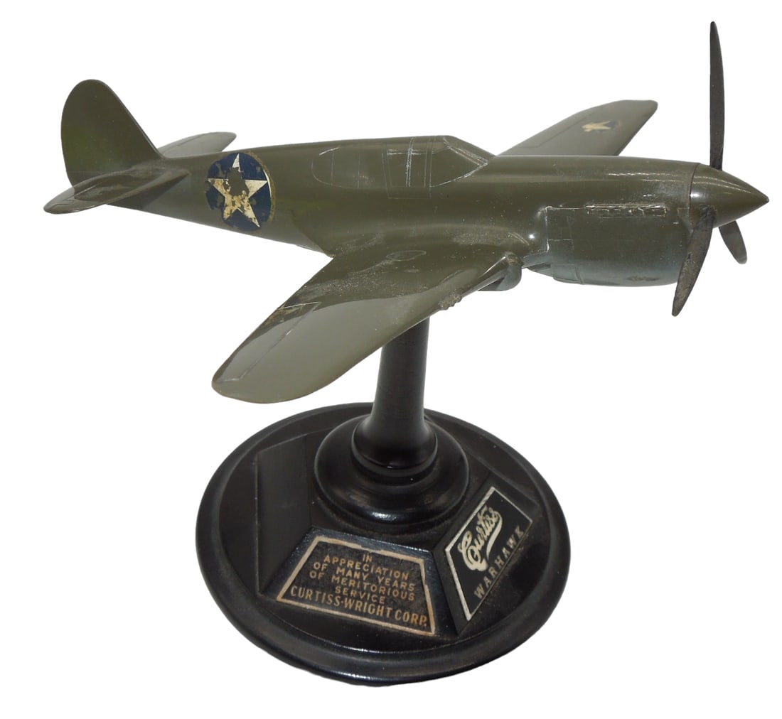 Curtiss P-40 Warhawk Fighter Airplane & Display Stand Employee Appreciation: Curtiss P-40 Warhawk Fighter Airplane & Display Stand. Given to employees, â€œIn appreciation of many years of meritorious service. Curtiss-Wright Corp.” Approximate size is 4.5 inches tall.