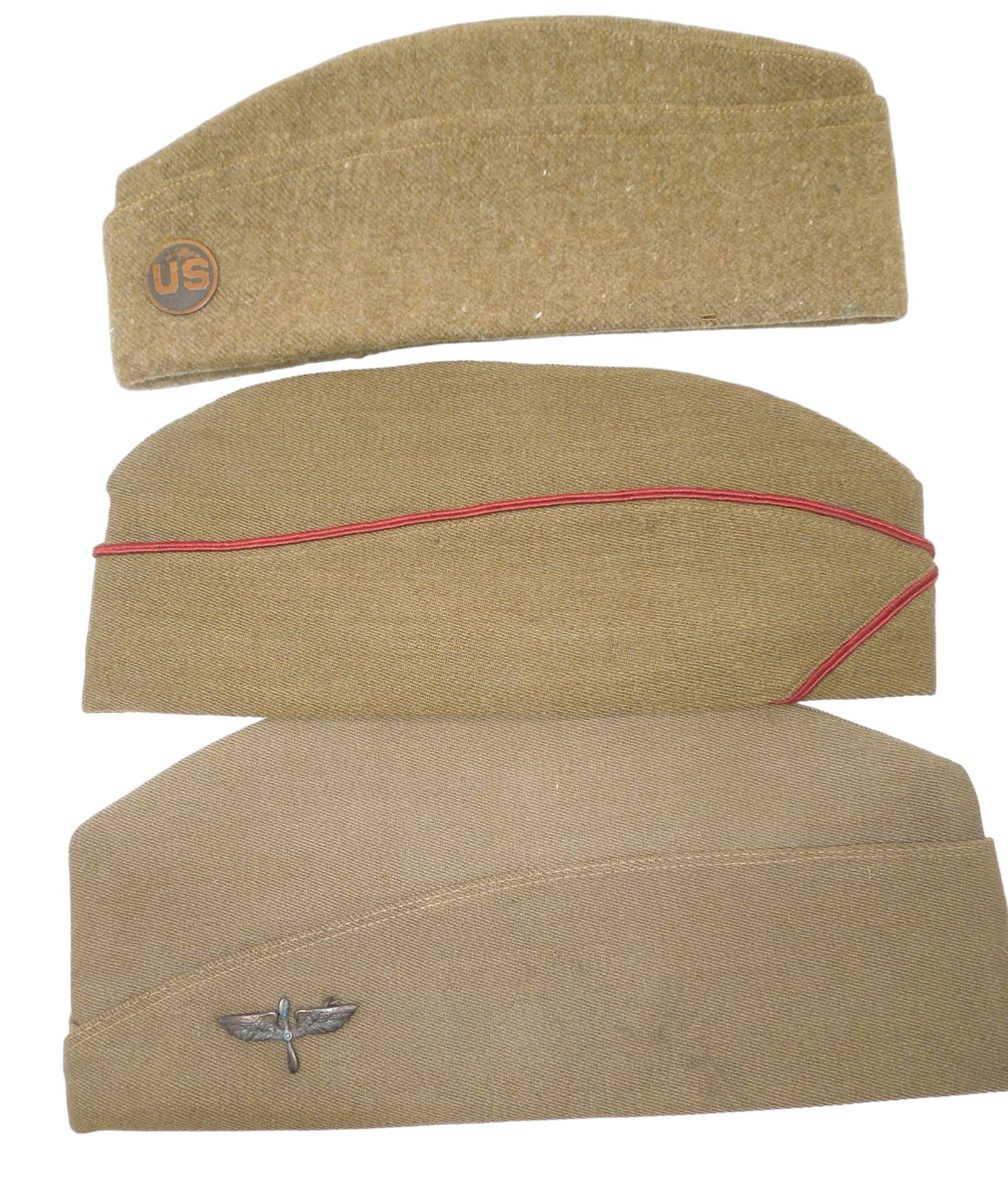 Lot (3) US Army WWI Overseas Caps Aero Squadron & Field Artillery Officer Named: Three WWI caps- Artillery piped named Officer cap, an enlisted wool cap with a US disc screwed on, and a private purchase cap with a costum wing and prop device for Aero Squadron use. All are in used