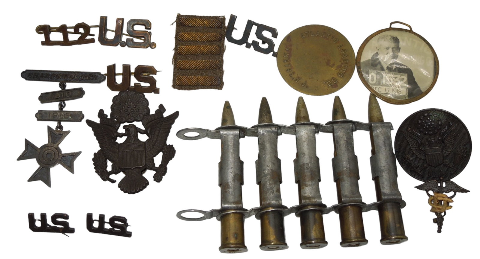 WWI US Military Pins Worker ID Badge Bullets Cap Badge Lot: Lot of pins and inert linked bullets as shown. Also an Atlantic Loading company 1918 dated worker Photo ID badge.