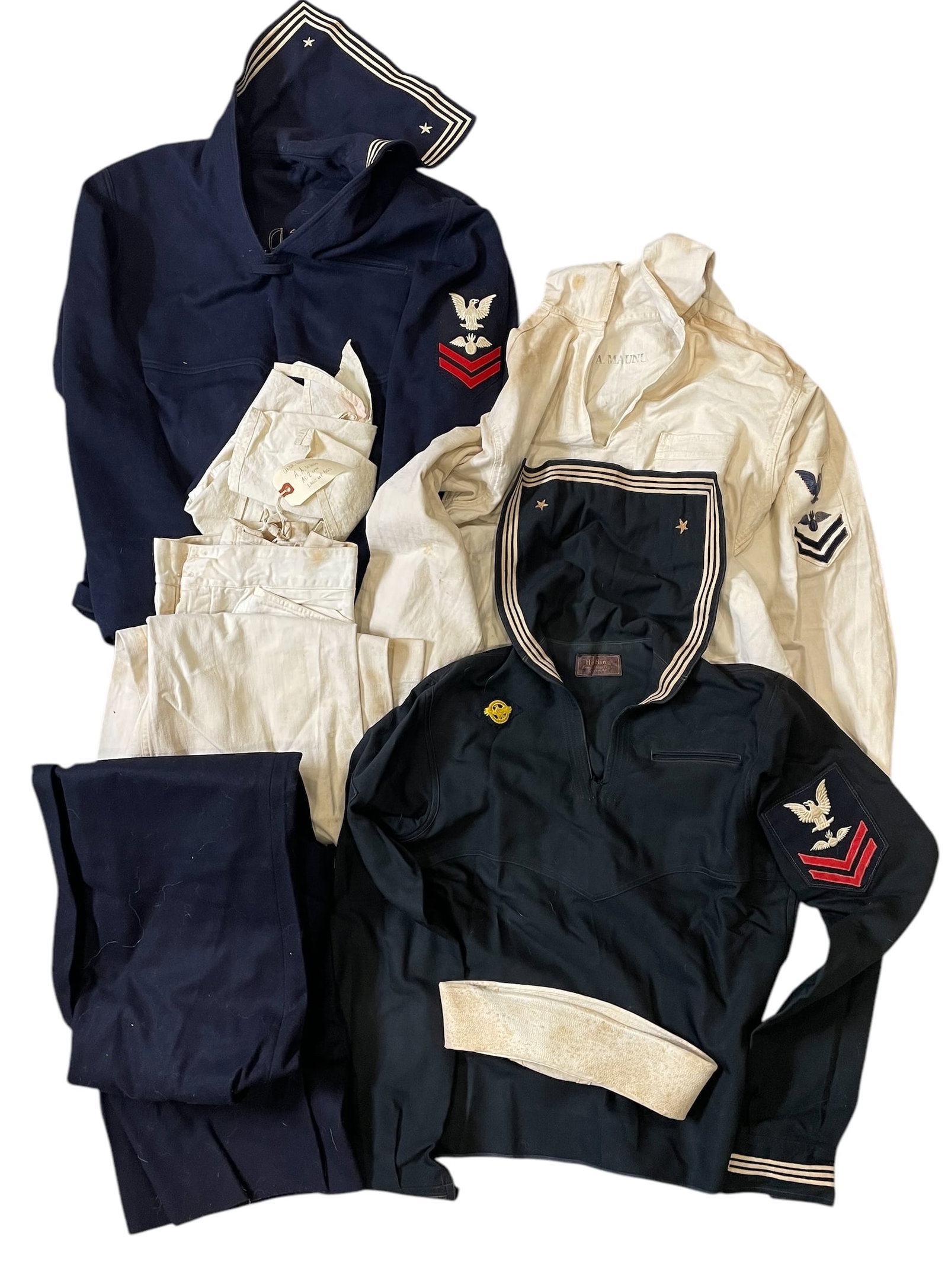 WWII Hawaii US Navy Named Sailor Aviation Uniform Group: Large lot of named Aviation sailor uniforms and duffel bag named to a US Navy WWII veteran of Hawaii. Named to A.A. Maunu. Many are soiled from age and wear.