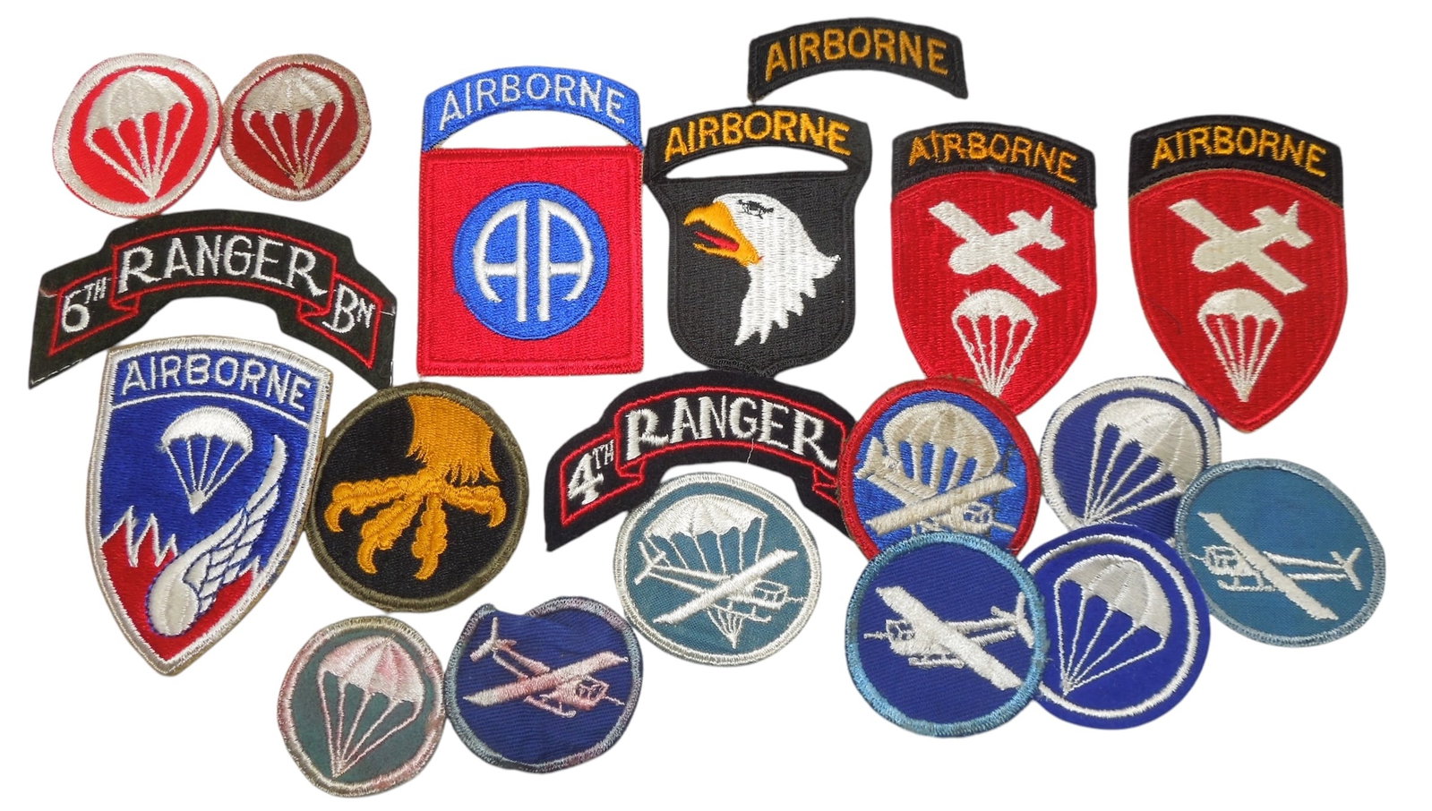 Lot WWII - 50s US Army Airborne Cap & Division Patches: Lot of Airborne cap and Glider patches, Ranger scrolls, one piece 82nd and 101st Airborne Division, and a Korean War 187th RCT. Good condition but some have glue or discoloraton stains.