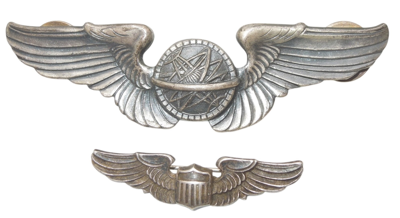 Lot (2) WWII US Army Air Force Sterling Navigator & Pilot Wings Pins: Original as shown. One 3 inch and one 1.5 inch sized.