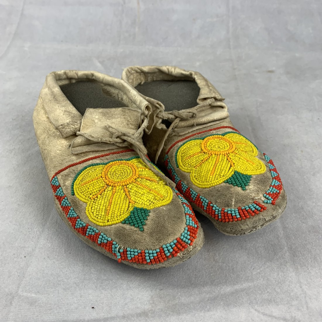 Vintage Pair Beaded Indian Moccasins: Pair of vintage beaded Indian moccasins. Nice soft hide. Beaded toes. 9or 10 missing beads is all. Retain the original ties Excellent condition. 9 inches long.