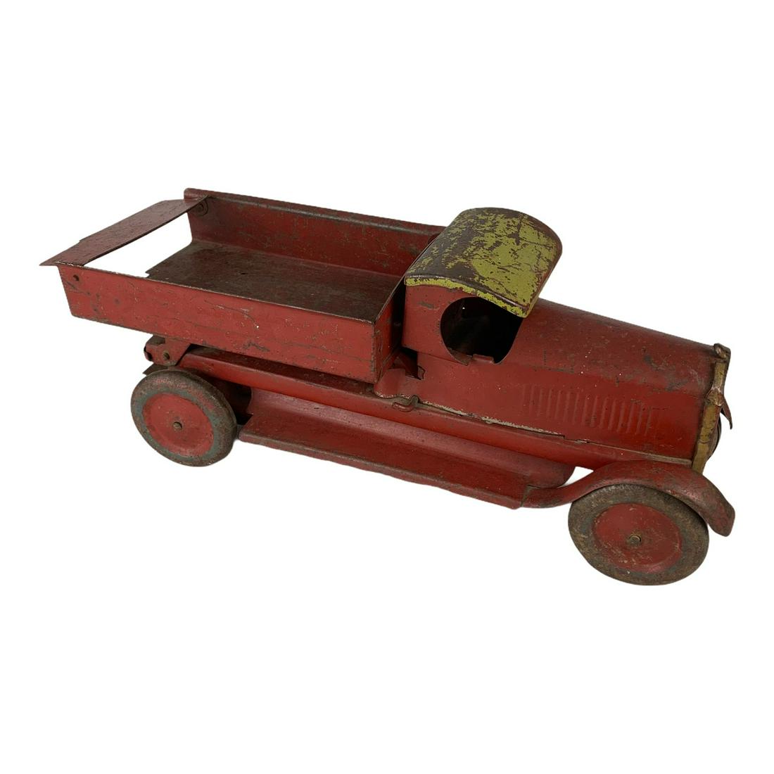 Early Pressed Steel Toy Truck [Mack}: Heavy pressed steel early toy dump truck. 16” long. Appears to be complete and original. Some paint wear as expected.