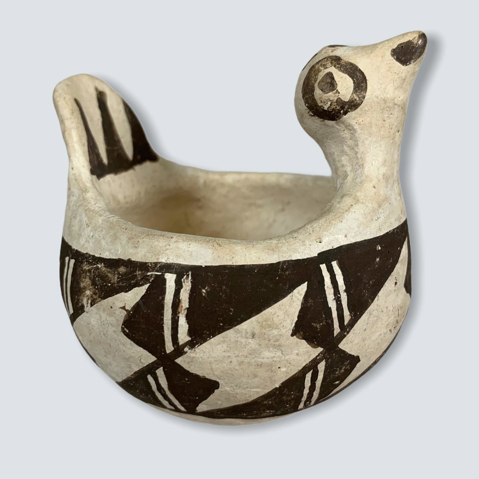 Acoma Figural Bird Bowl: An old Acoma bowl shaped in the figure of a bird, signed, "ACOMA N.M." on the underside, decorated in white and brown. Measures 3 inches x 3 inches. In good condition.