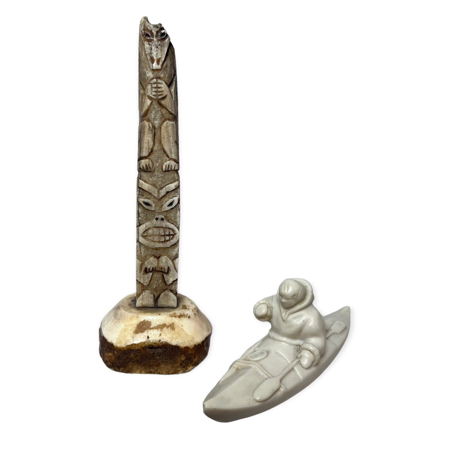 Eskimo in Kayak With Seal & Carved Bone Totem: A 6 1/2 inch eskimo in kayak with seal composite figurine. One very small nick at tip of kayak. A very unique Bone carved totem pole. 7 1/4 inch. great patina and condition with one chip on top right 