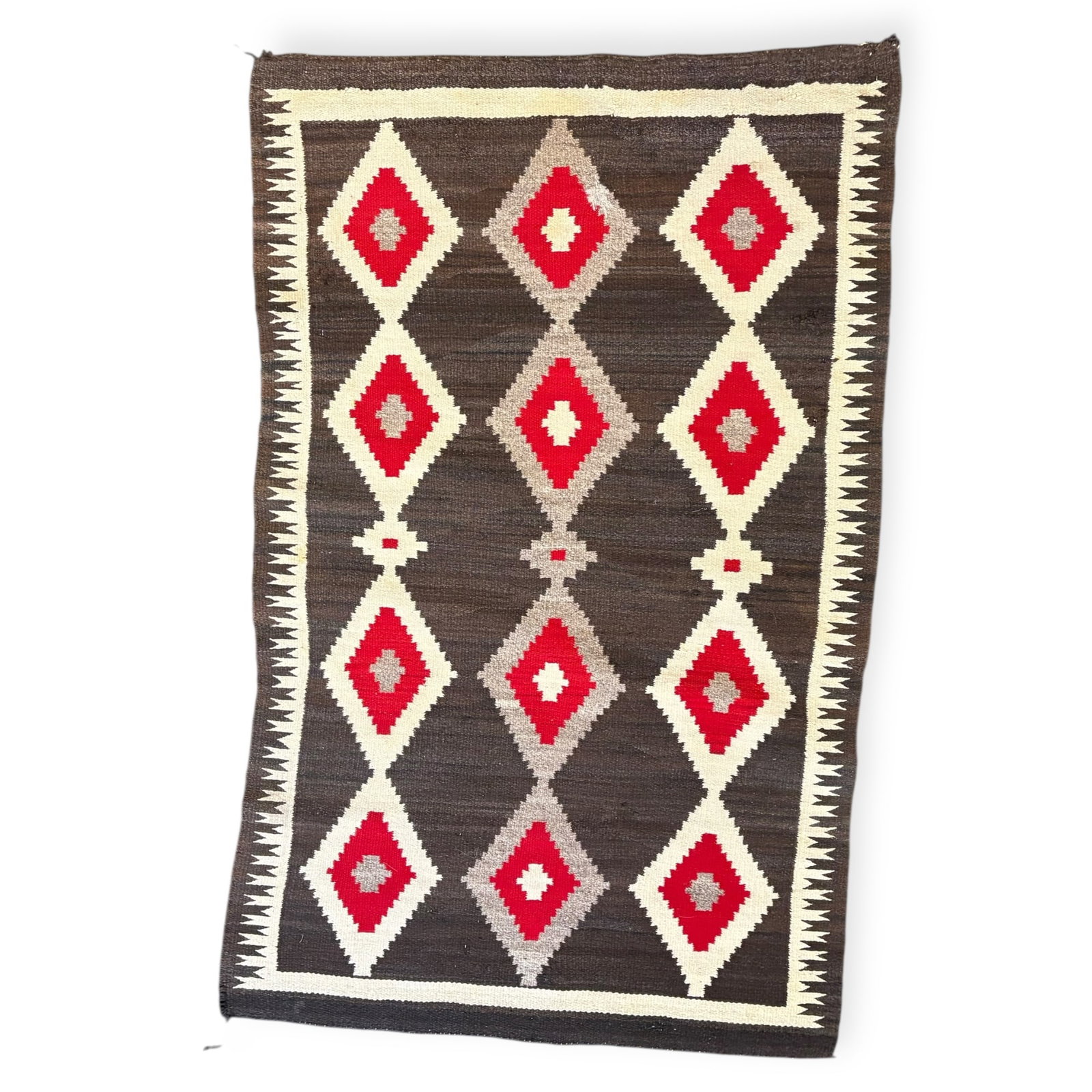 Regional Navajo Rug: Measures approx 56.5 x 34.5, circa 1920-1930. Nice black/brown background. Some area of wear, and repair. A rug hanger has been attached to the top backside. A fine example