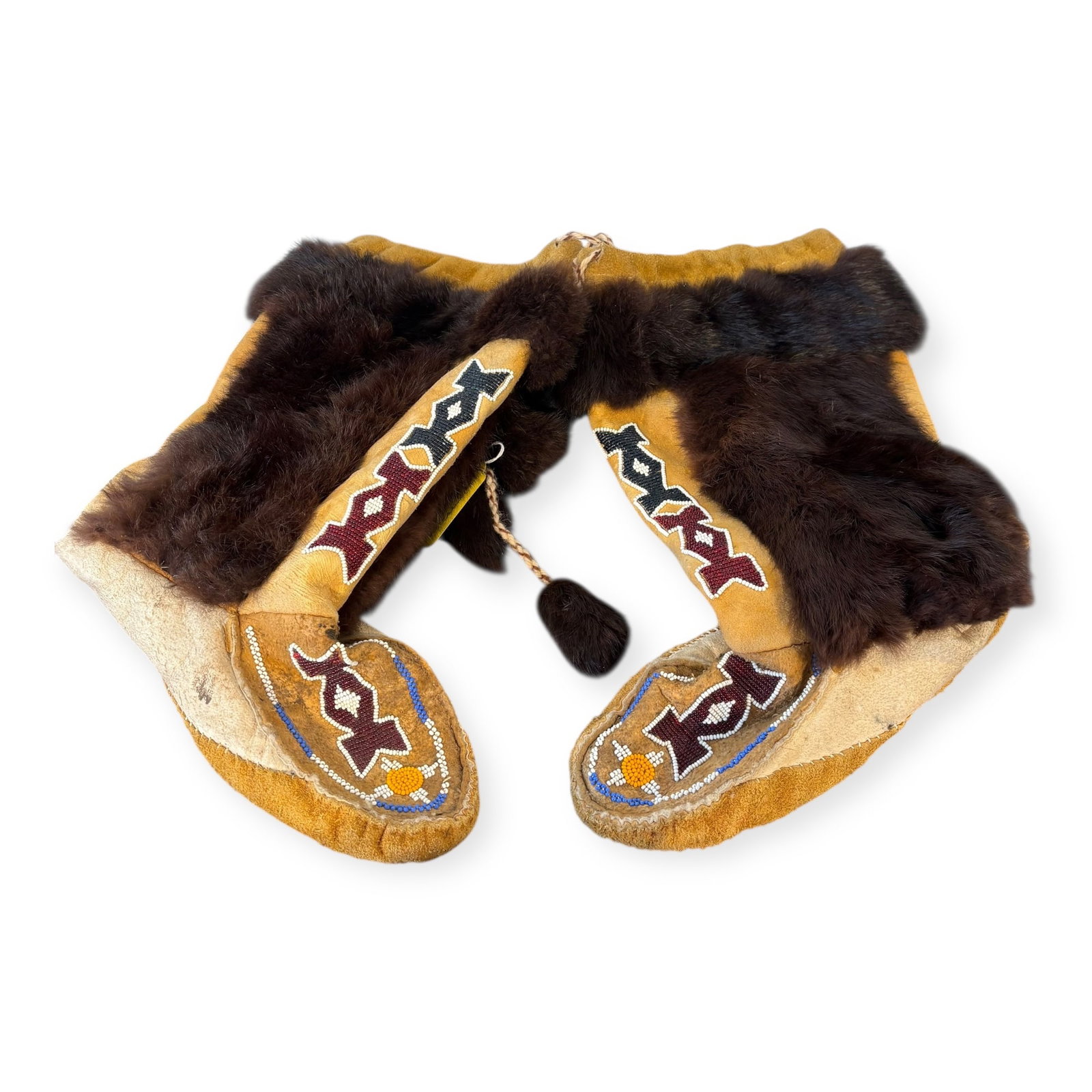 Late 20th C Northern Cree Mukluk Moccasins: Measuring approx 14 inches tall. A vintage pair of Cree high top moccasins, decorated throughout with beadwork and fur ornaments to sides. In good overall condition. Circa second half 20th century.
