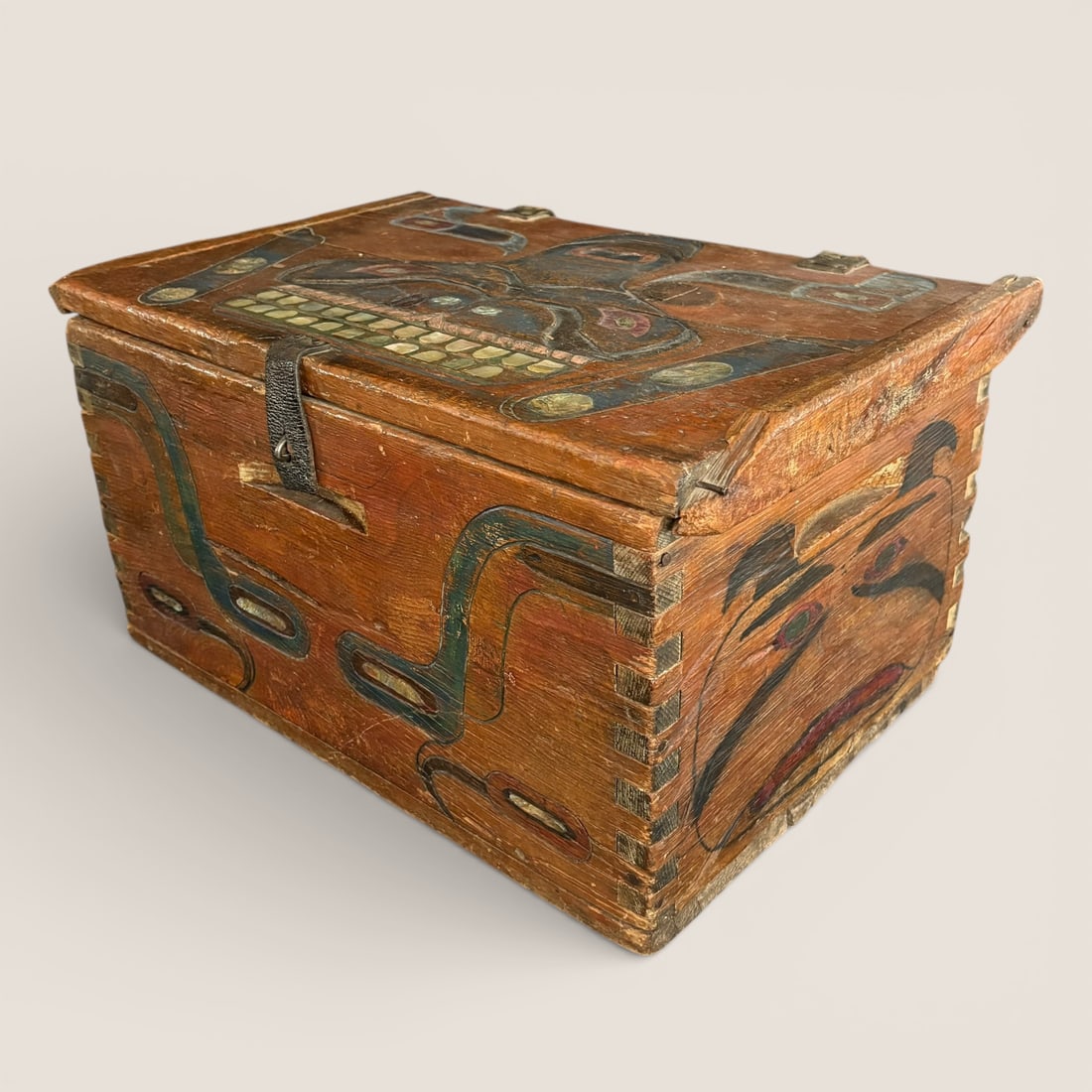 Northwest Coast Polychrome Storage Chest with Abalone Inlay: Measuring approx 22 x 11.5 x 13.5 inches. This exceptional Northwest Coast wooden storage chest is boldly decorated with classic formline imagery, centered by a powerful mask-like face across the fron