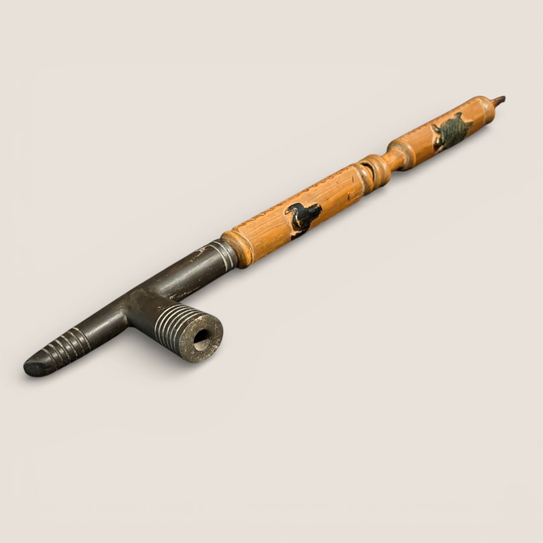 Important Figural Sioux Pipe, 19th C: An exceptional Sioux pipe with an ash stem including carved figures of a bull/buffalo and turtle, with puzzle rings at the center. The sides of the stem have notches with red pigment. The steatite bow