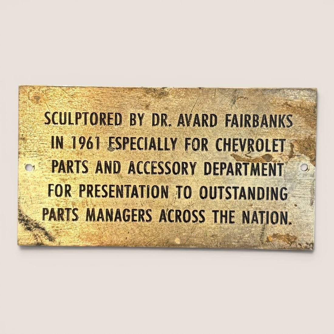 1961 Chevrolet Parts and Accessory Department Presentation Plaque by Dr. Avard Fairbanks: This is a rectangular metal award plaque commissioned by Chevrolet in 1961. The plaque is fashioned from a heavy golden-toned metal, likely brass or bronze, and features five lines of recessed black u