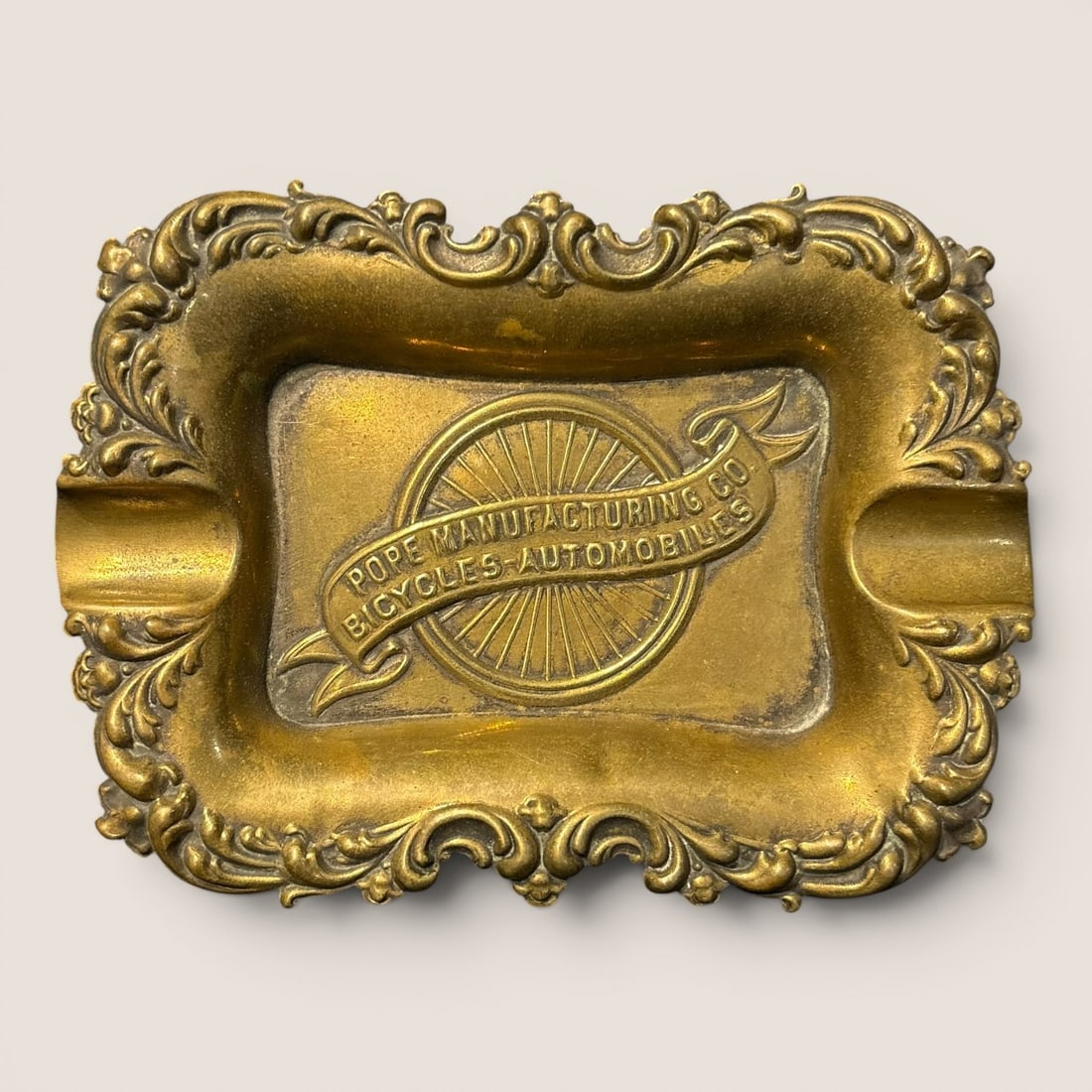 Antique Pope Manufacturing Co. Cast Metal Advertising Ashtray: An antique advertising ashtray produced for the Pope Manufacturing Company, constructed from cast brass or bronze-plated white metal. The rectangular piece features a central recessed well with a high