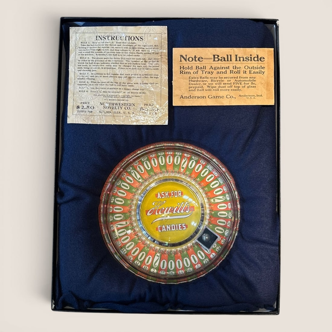 Vintage Northwestern Novelty Co. Hewitt's Candies Ball-in-Rim Trade Stimulator: This vintage manual countertop trade stimulator was manufactured by the Northwestern Novelty Co. of Morris, Illinois. The device is a ball-in-rim gambling game consisting of a circular tray with a gla
