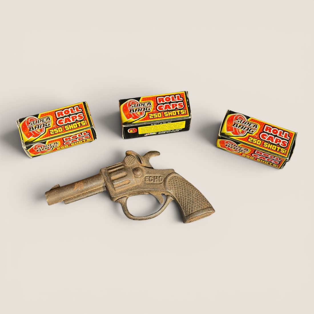 A Collection of Four Pieces Comprising an ECHO Toy Cap Gun and Three Boxes of Super Bang Roll Caps (1 of 1)