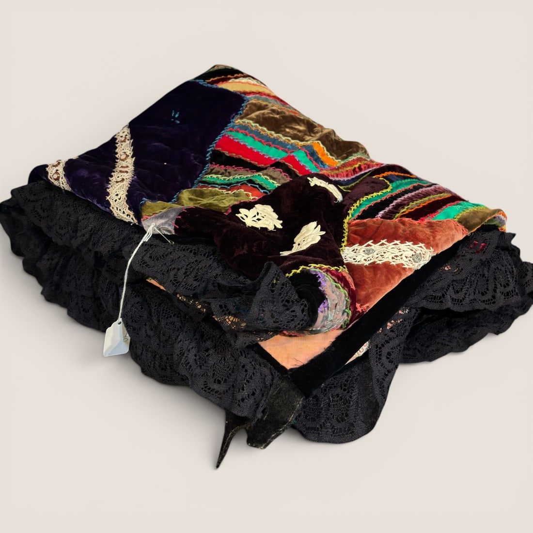 Late Victorian Crazy Quilt Silk and Velvet Patchwork Skirt with Lace Ruffles: This textile item is a late Victorian era garment, dating approximately from 1880 to 1910, constructed using the crazy quilt technique. The piece features an assortment of irregularly shaped patches c