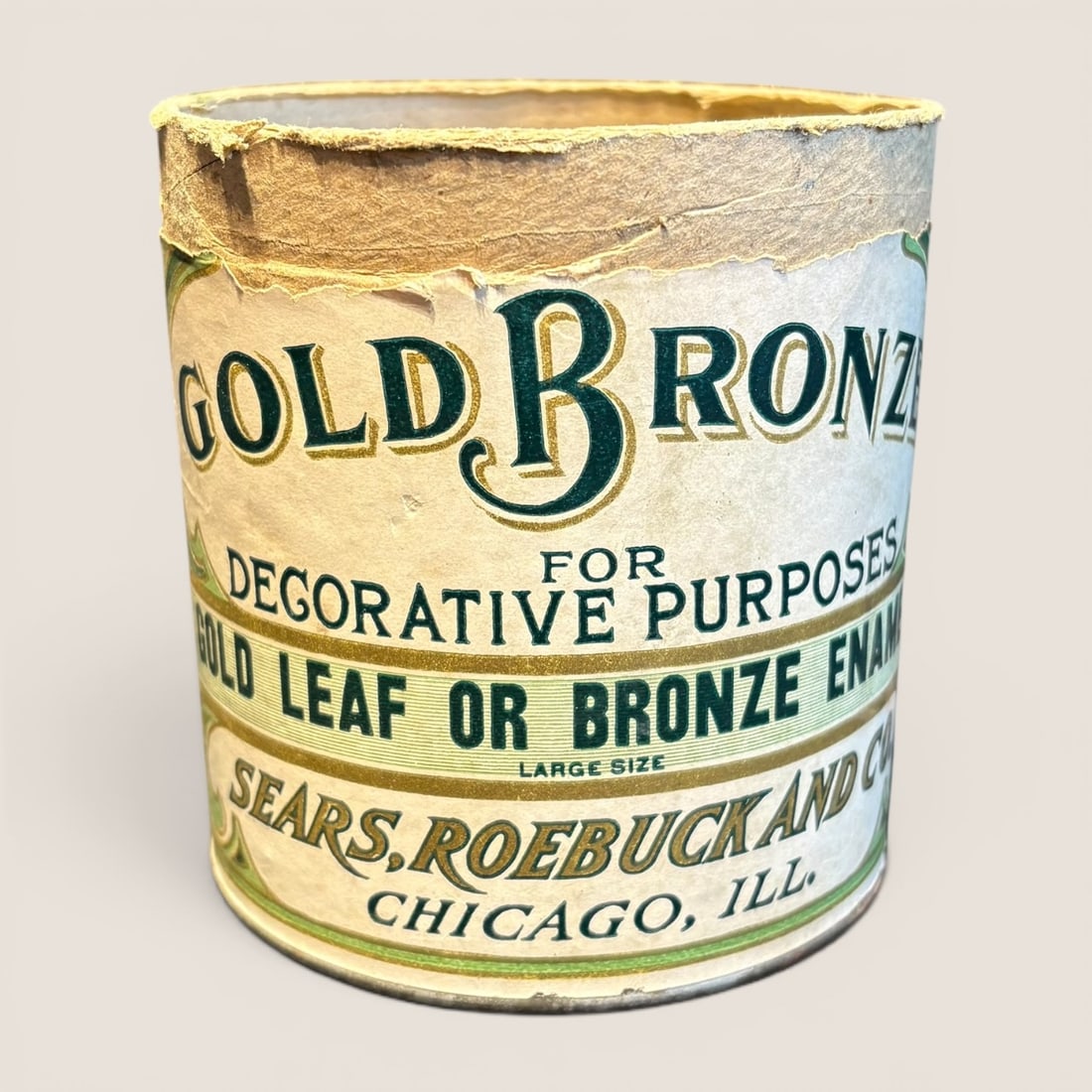 Antique Sears, Roebuck and Co. Gold Bronze Decorative Paint Advertising Container: This is an antique cylindrical advertising container for Gold Bronze decorative paint, manufactured by Sears, Roebuck and Co. of Chicago, Illinois. The object consists of a fiberboard or cardboard